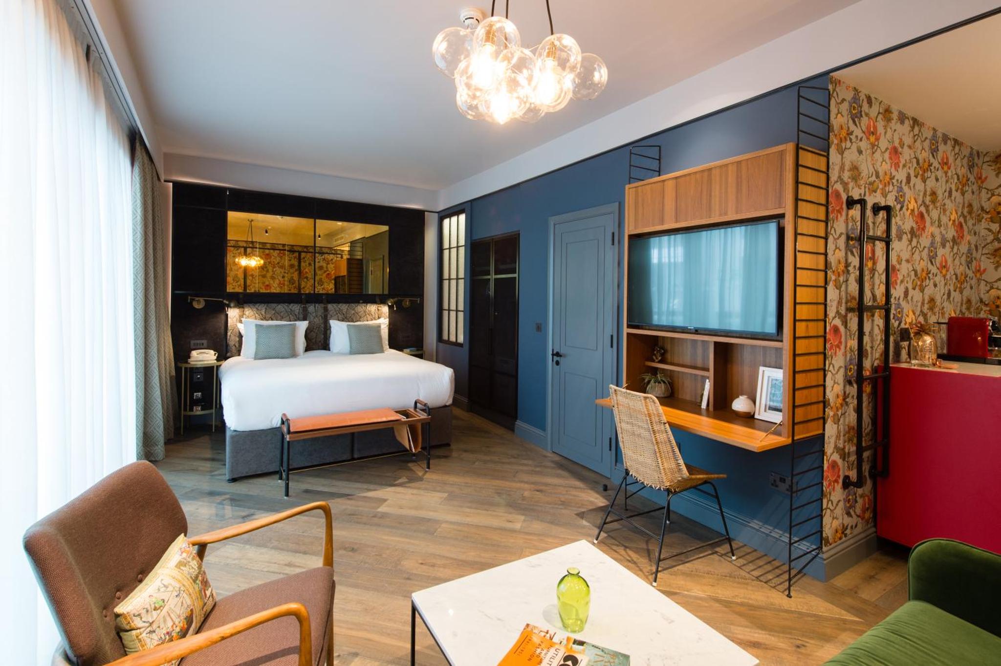 a hotel room with a bed and a living room at Clayton Hotel City of London, Tower Bridge in London