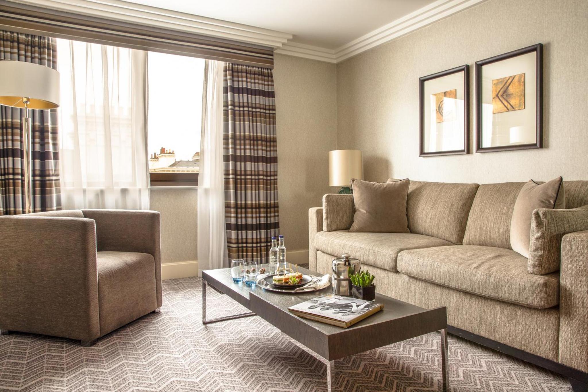 a living room with a couch and a table at The Lowndes London - A Jumeirah Partner Hotel in London