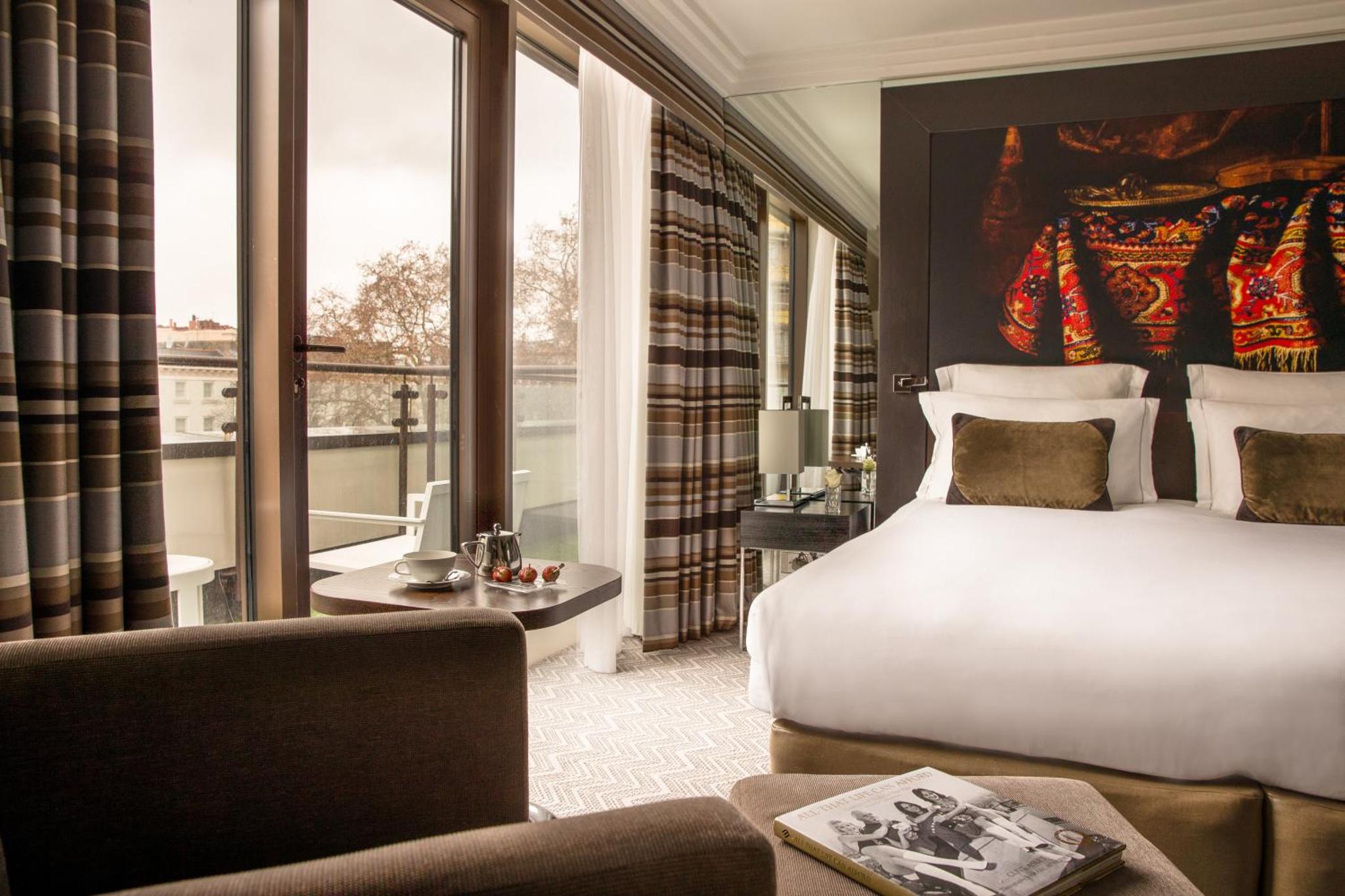 a bedroom with a bed and a large window at The Lowndes London - A Jumeirah Partner Hotel in London