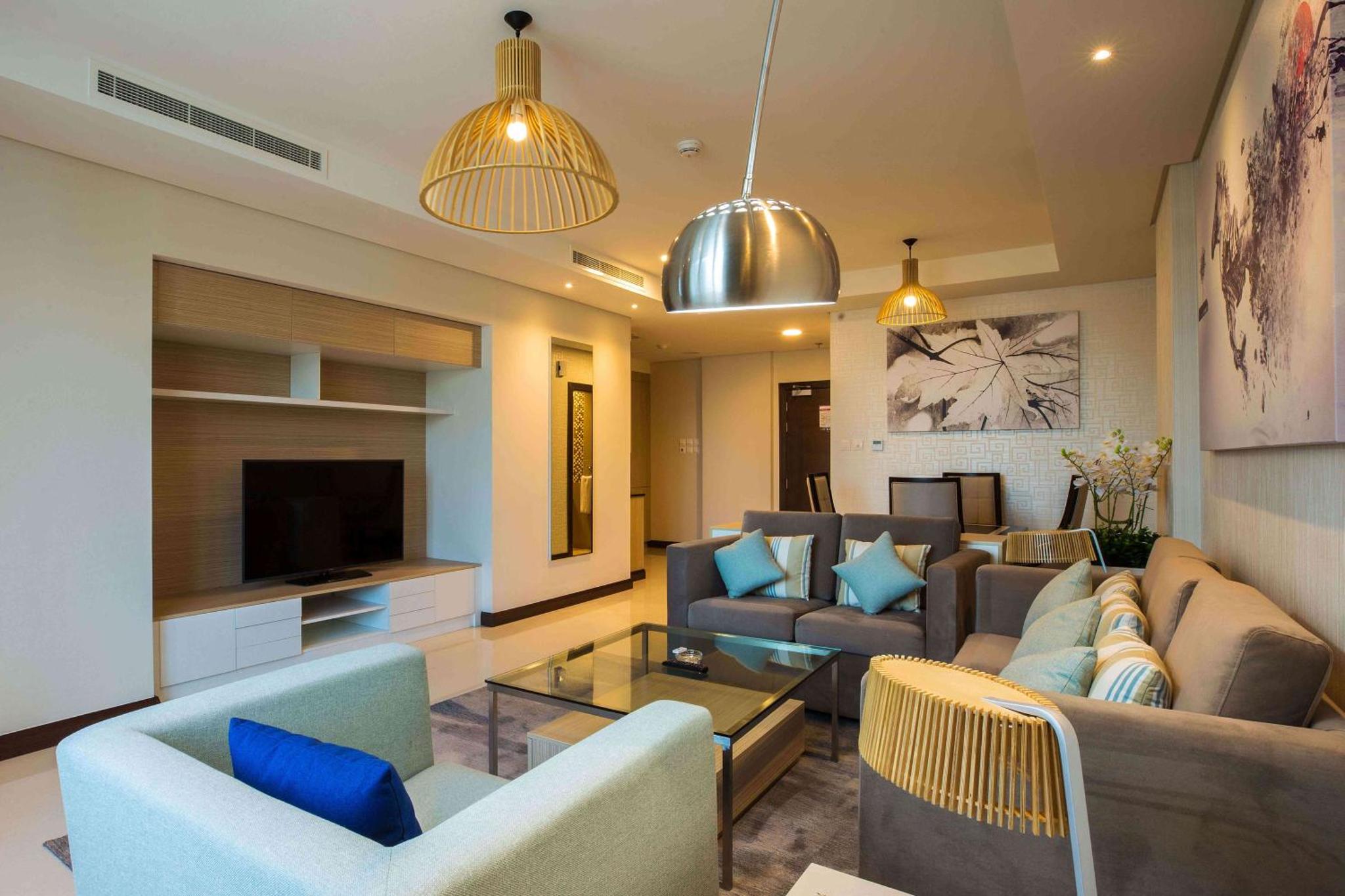 a living room with two couches and a television at Gulf Executive Hotel & Residence Juffair in Manama