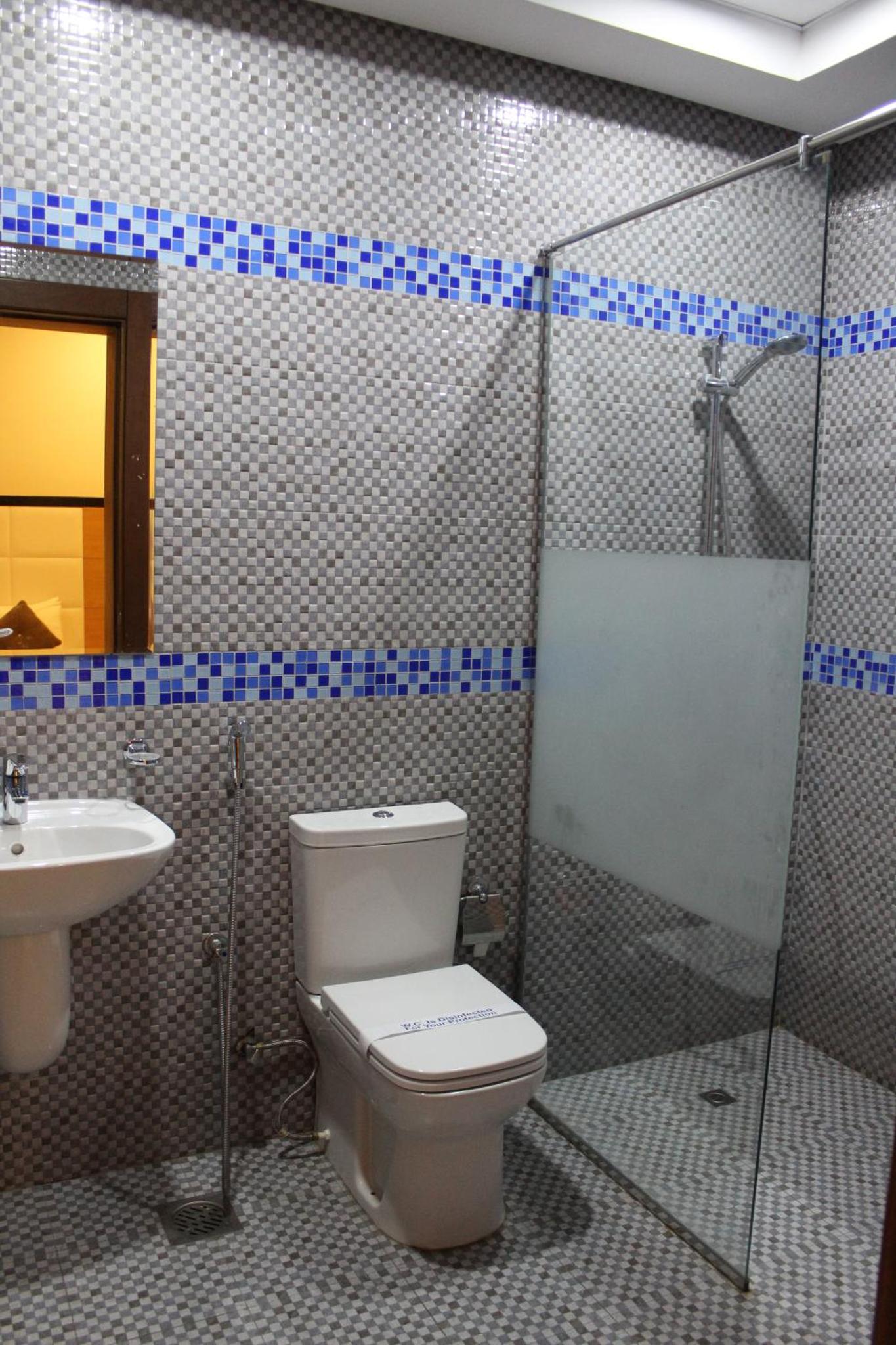 a bathroom with a toilet and a sink at Asian Tower in Al Ghurayfah