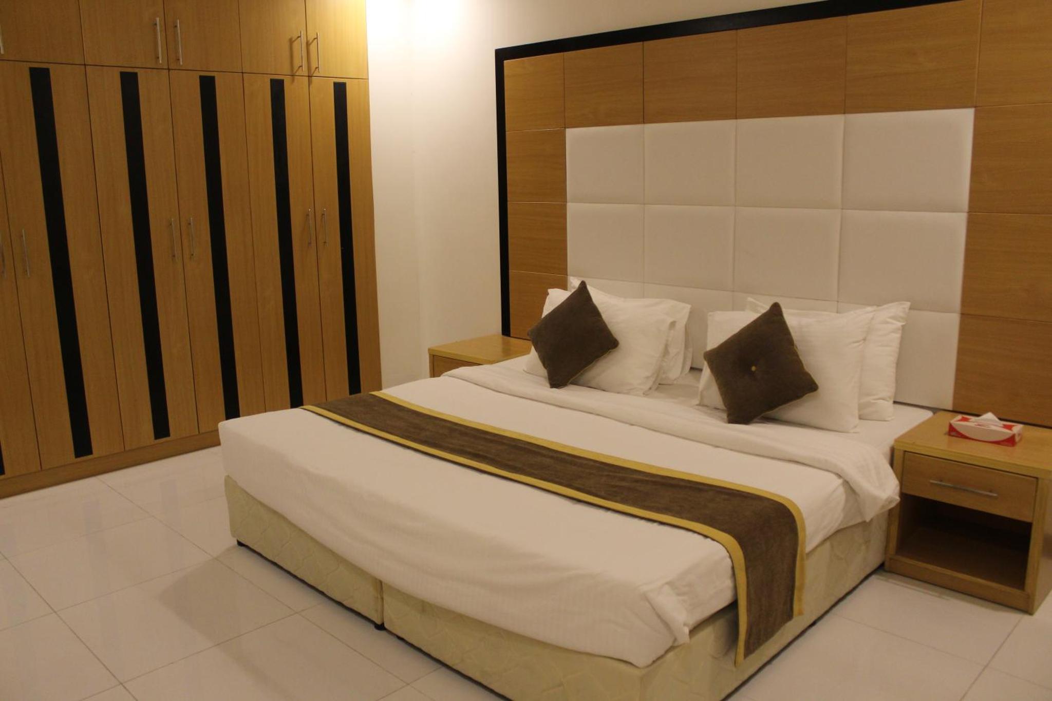 a bedroom with a large bed with white sheets and pillows at Asian Tower in Al Ghurayfah