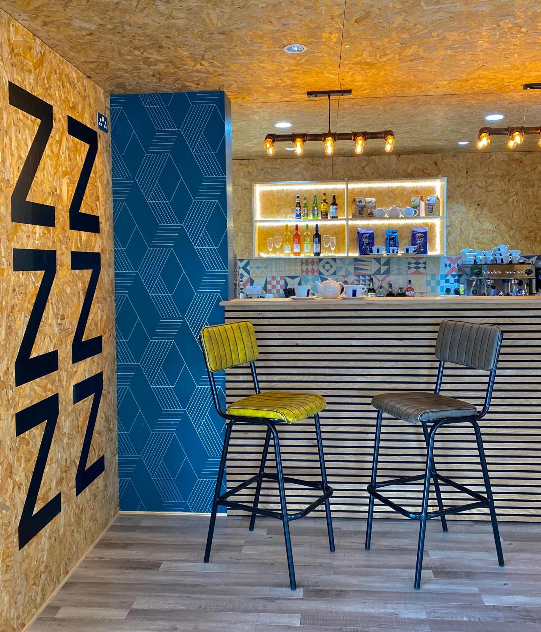 two chairs sitting at a bar in a restaurant at Snoozebox Olympic Park in London +16 photos