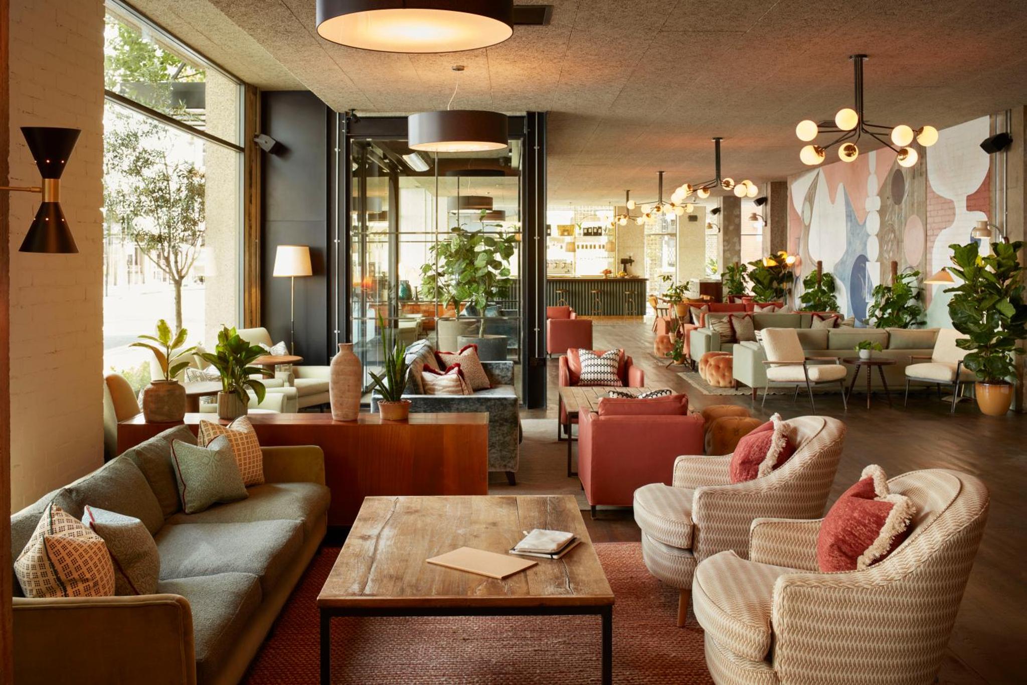 a lobby with couches and chairs and a table at The Hoxton, Holborn in London