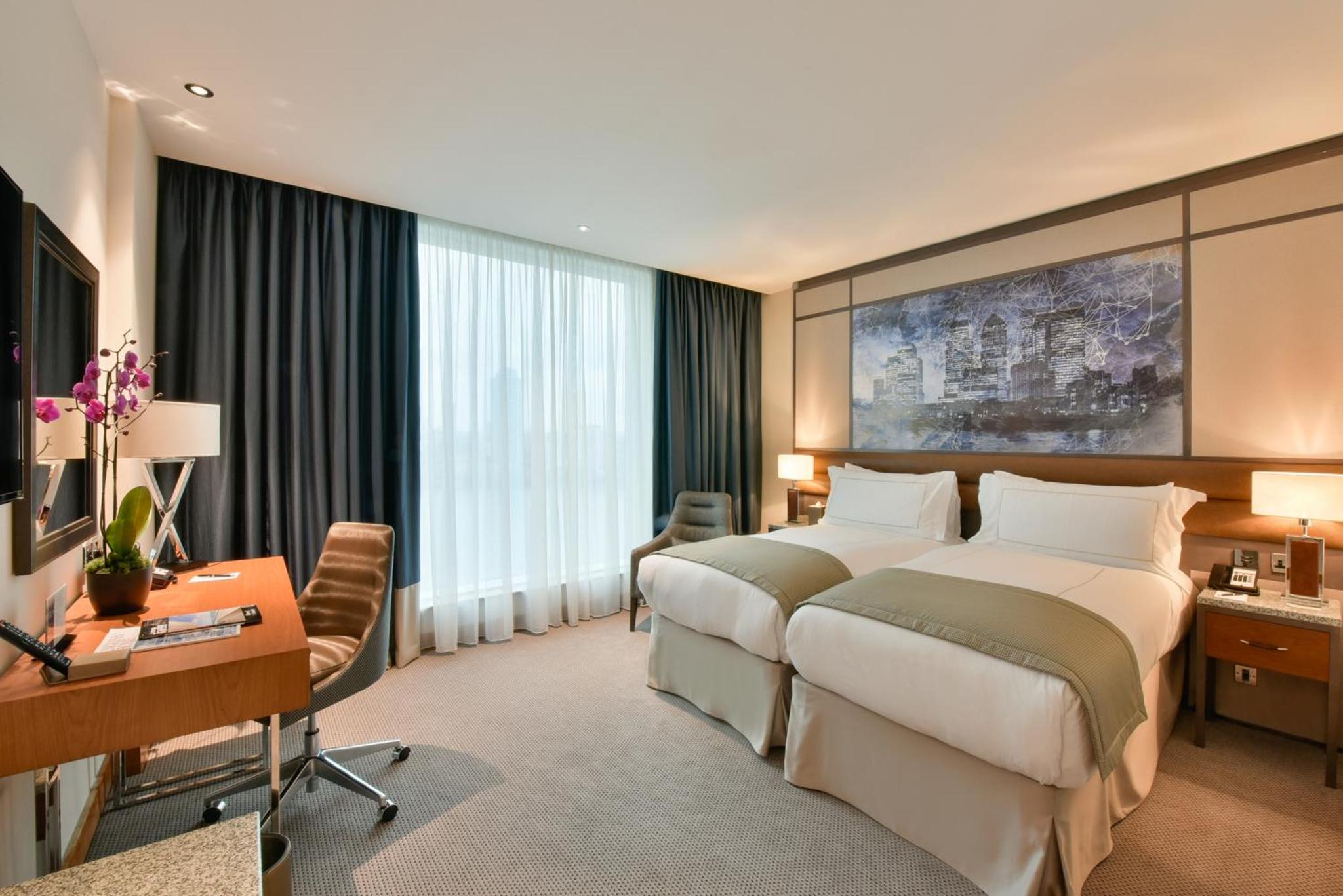 a hotel room with two beds and a desk at InterContinental London - The O2 in London