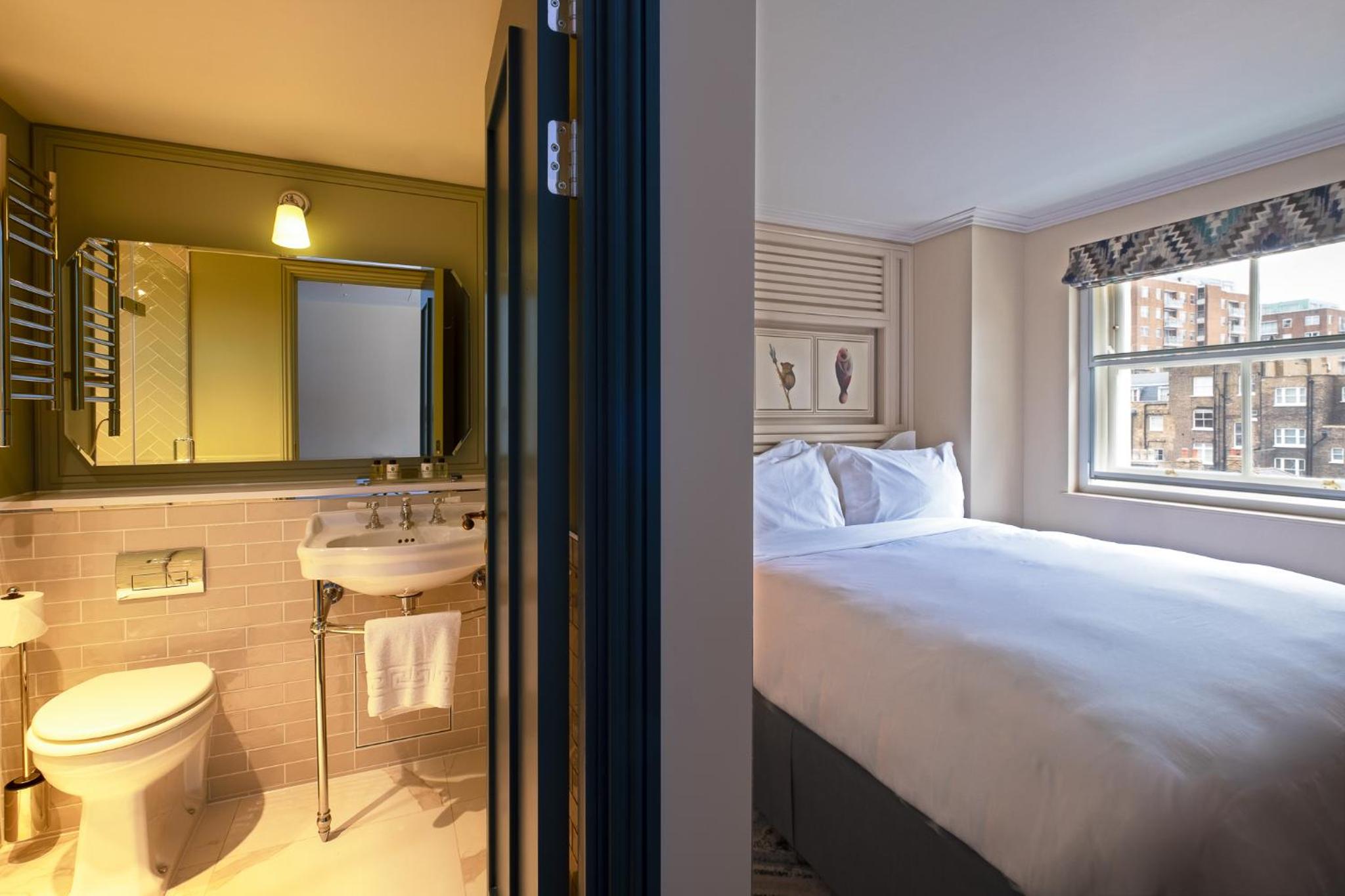 a hotel room with a bed and a sink at Home House Studio in London