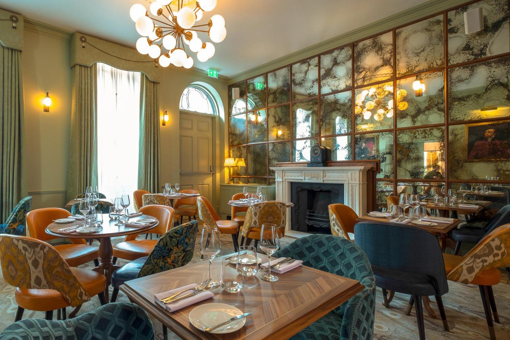 a restaurant with tables and chairs and a fireplace at Home House Studio in London +35 photos