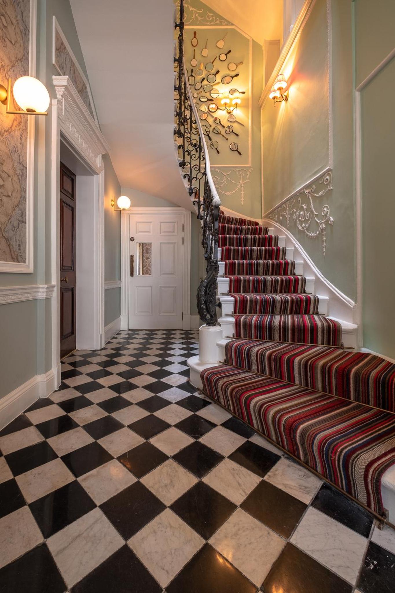 a hallway with a staircase with a checkered floor at Home House Studio in London