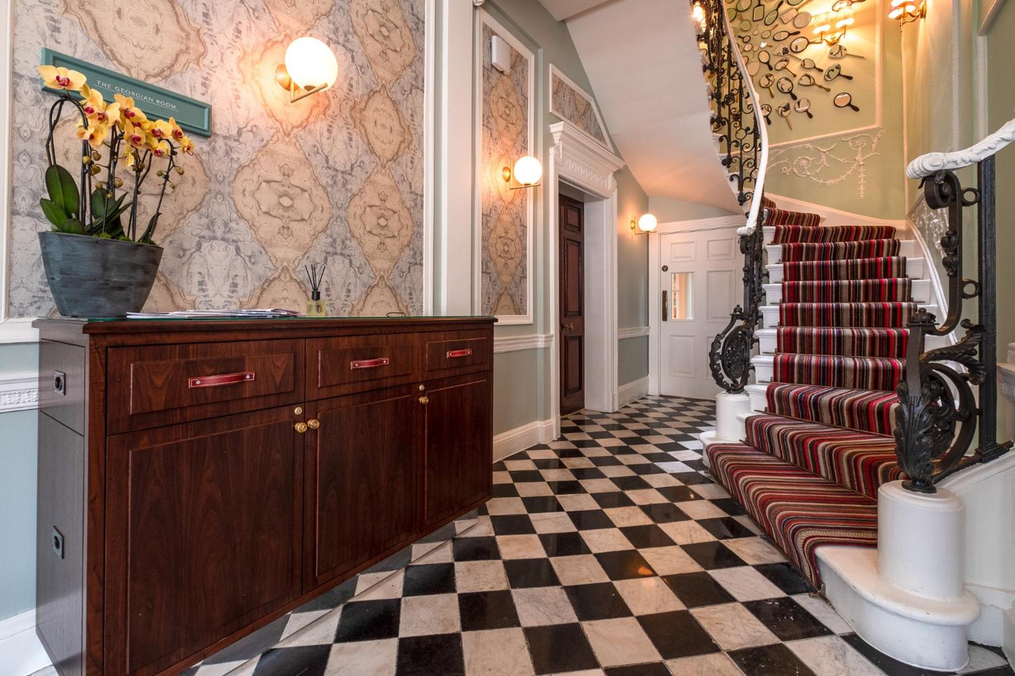 a hallway with a staircase with a checkered floor at Home House Studio in London