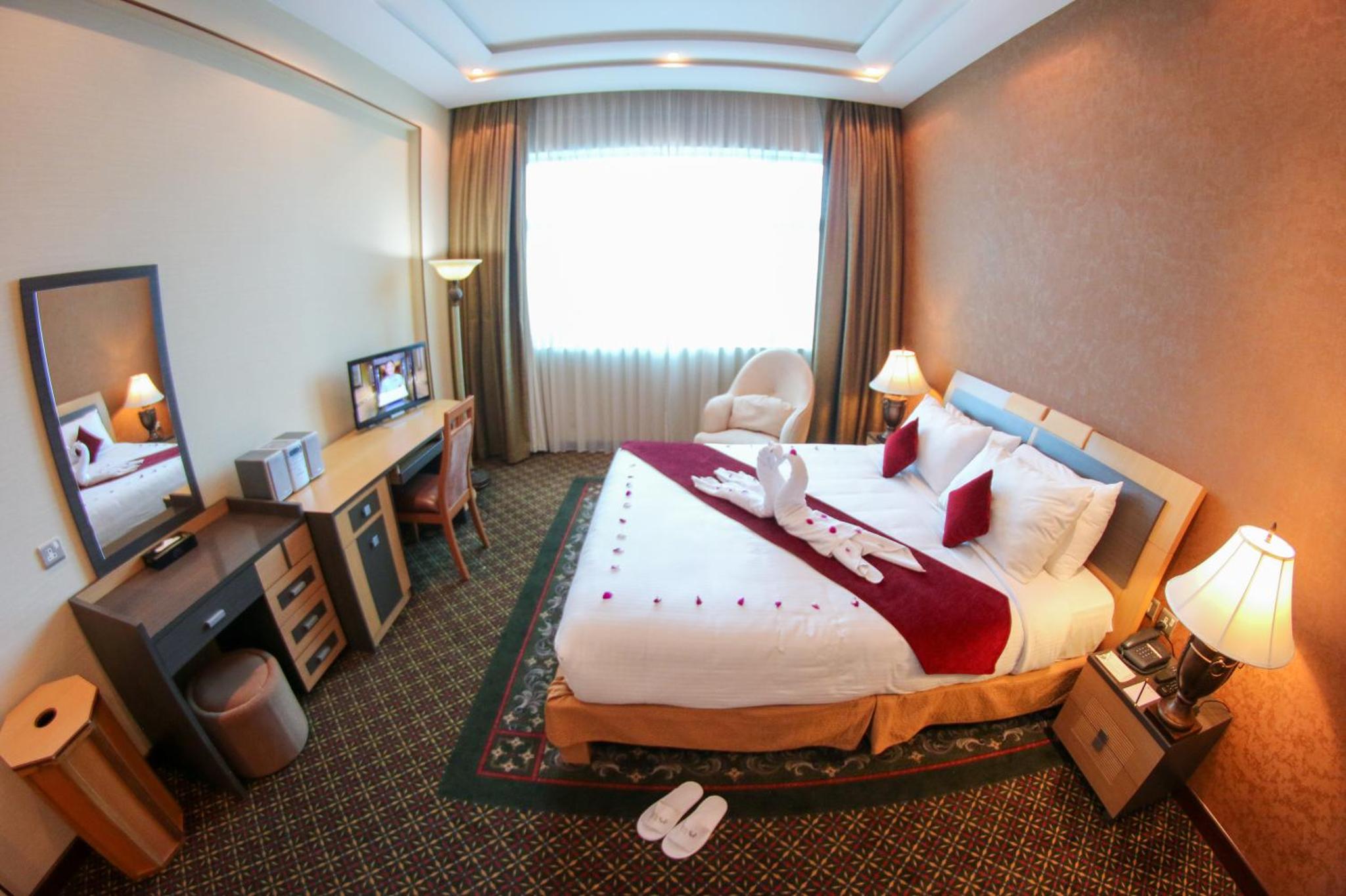 a hotel room with a large bed and a window at City Center Hotel in Manama