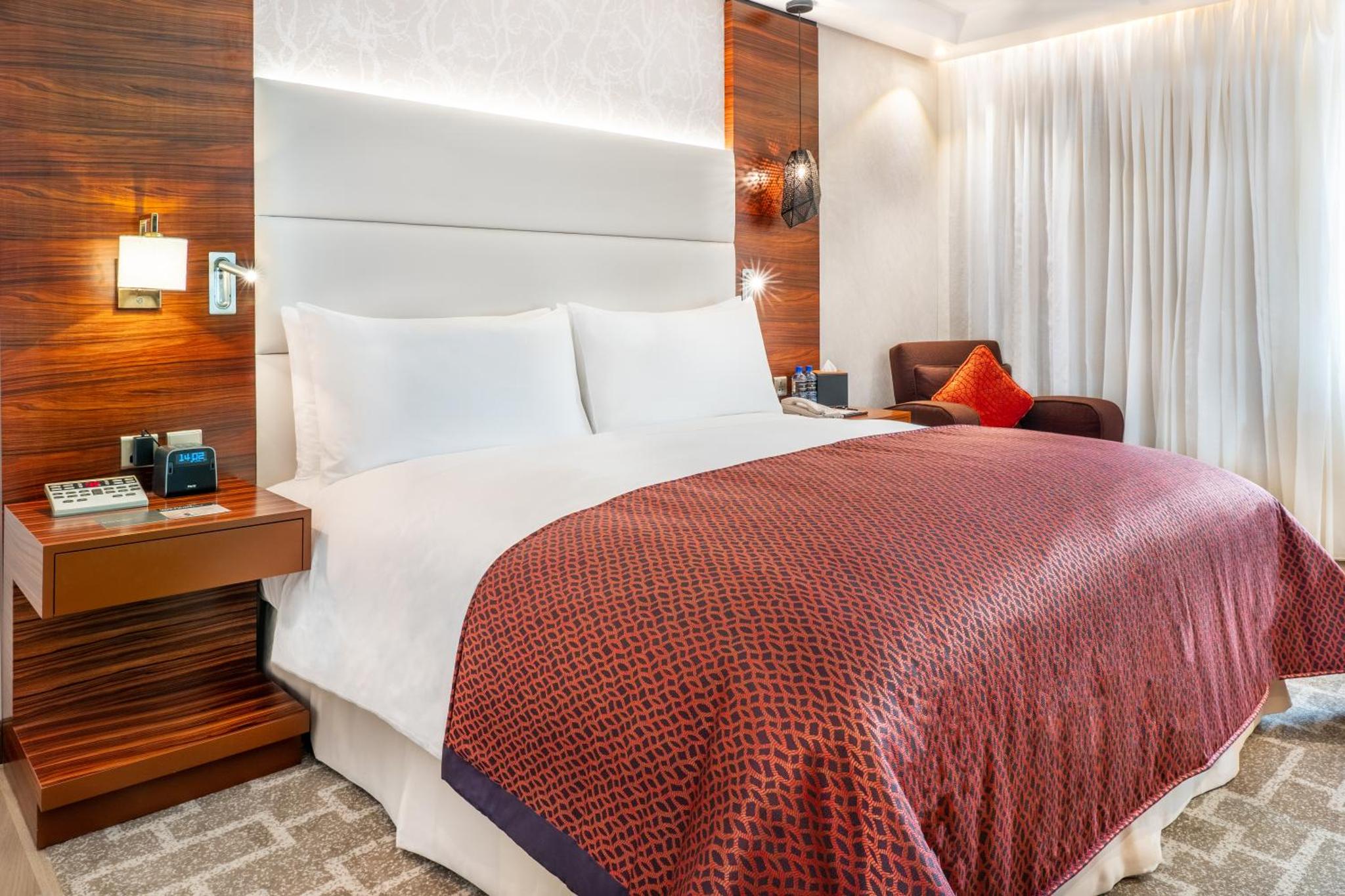 a hotel room with a bed and a chair at InterContinental Bahrain by IHG in Manama +203 photos