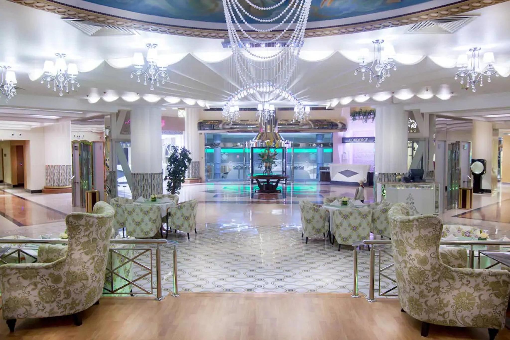 a lobby with chairs and a chandelier and a dance floor at Panorama Hotel and Spa in Manama
