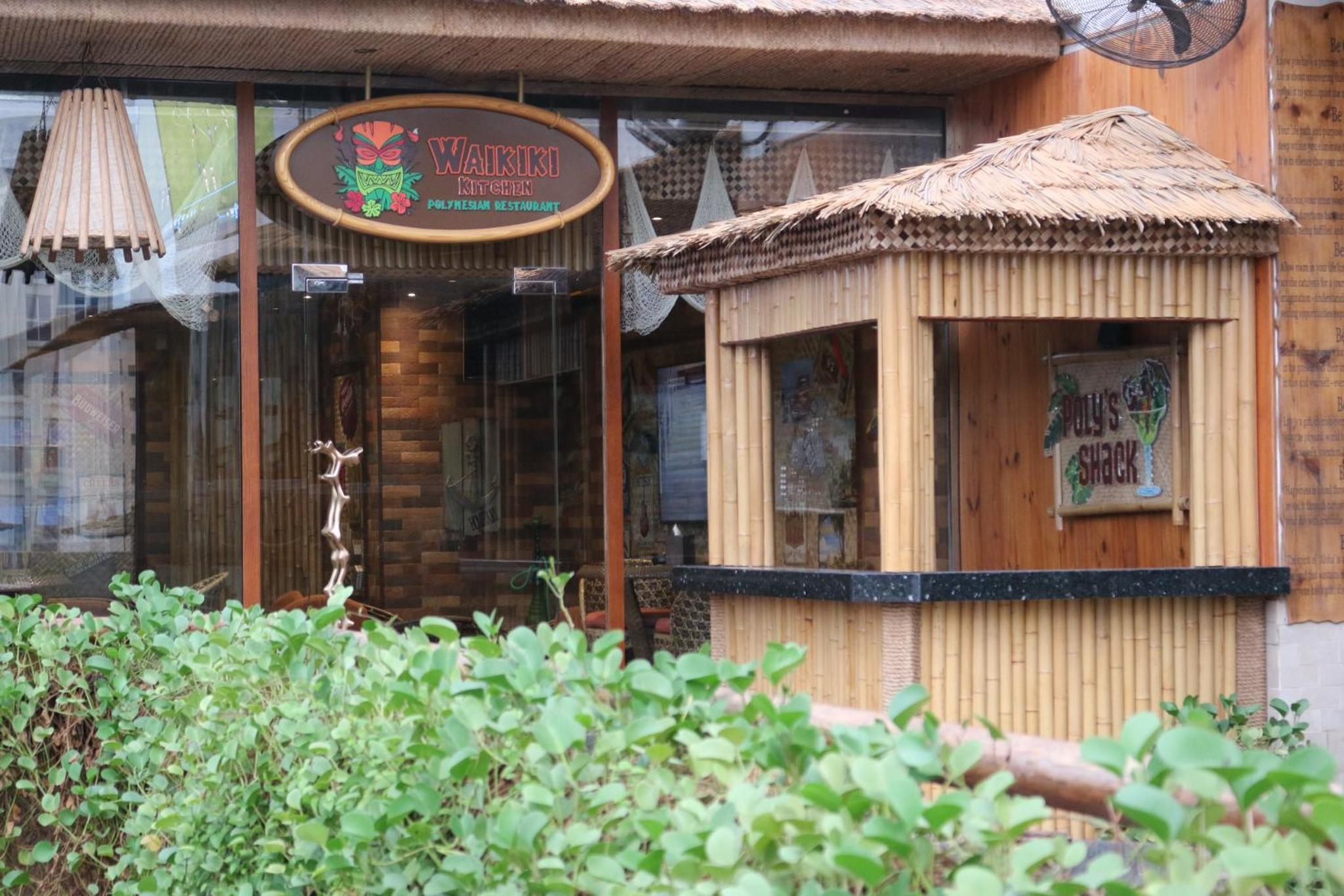 a restaurant with a sign on the side of a building at Elite Crystal Hotel in Manama