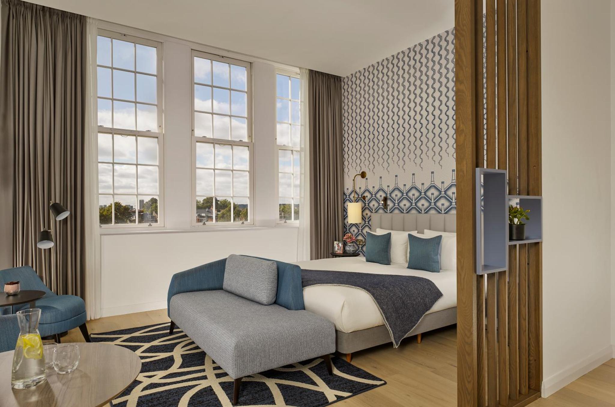 a bedroom with a bed and a couch and a table at Citadines Islington London in London