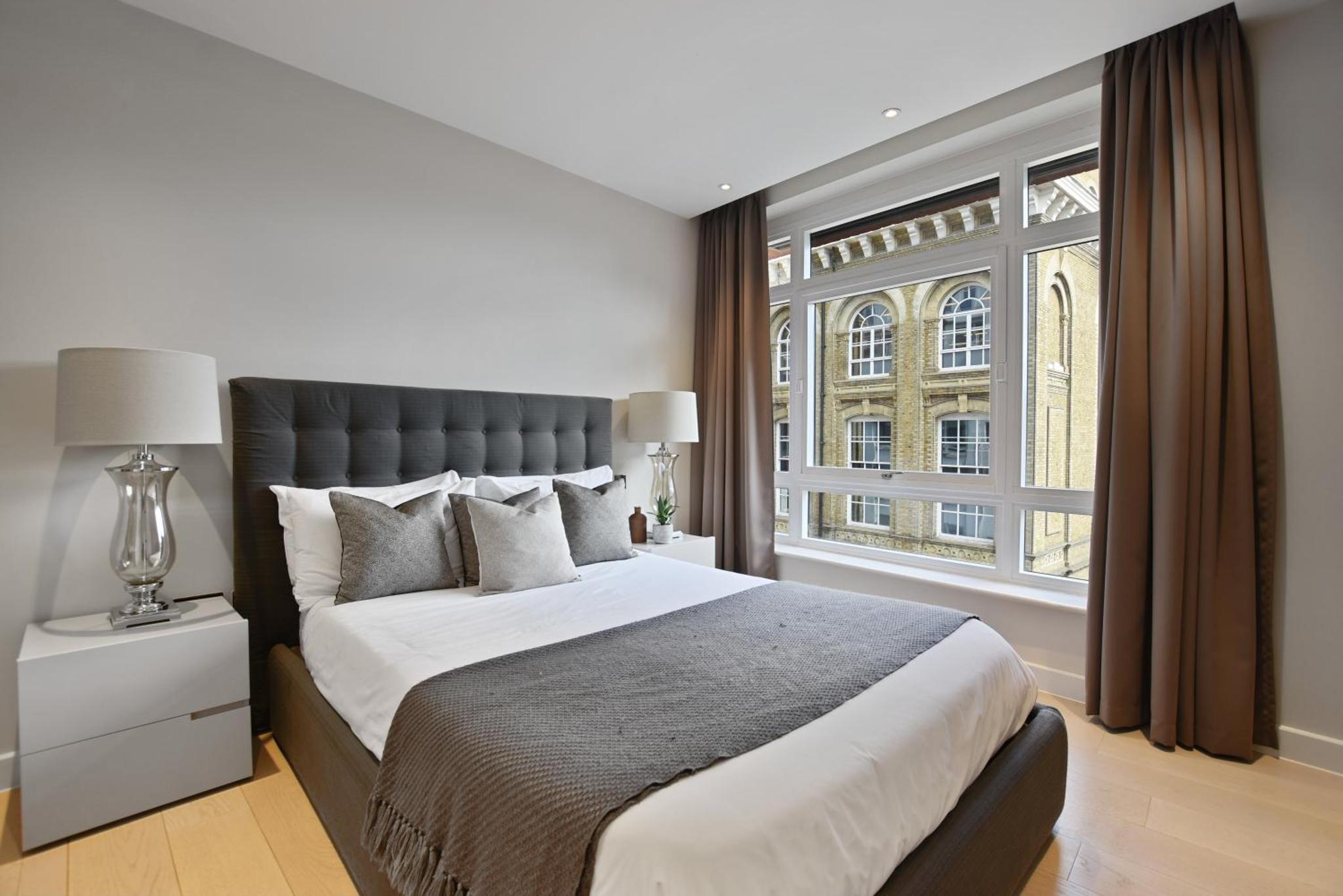 a bedroom with a large bed and a large window at Vauxhall Bridge Road by Aeria Apartments in London