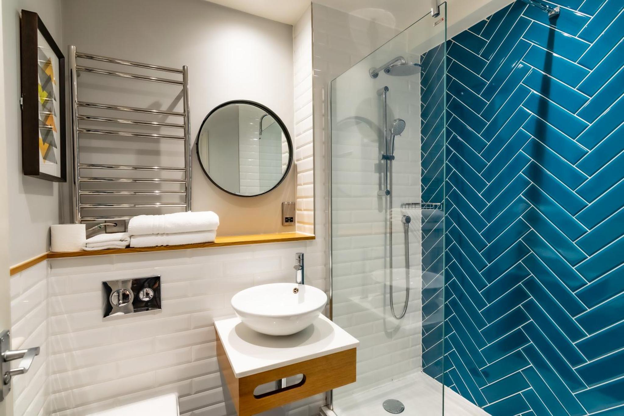 a bathroom with a sink and a glass shower at Victoria Inn in London +44 photos
