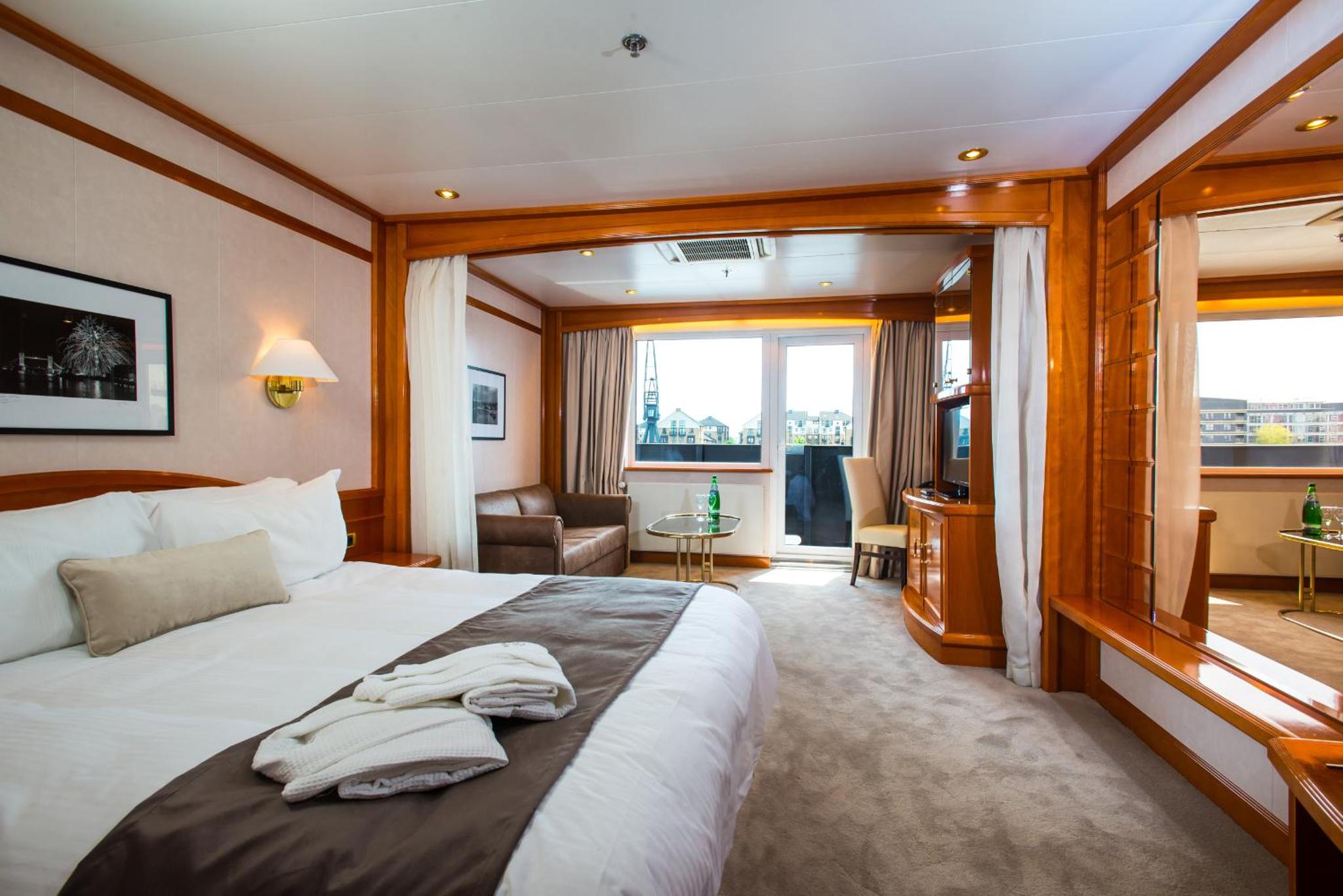 a bedroom with a large bed and a living room at Sunborn London Yacht Hotel in London