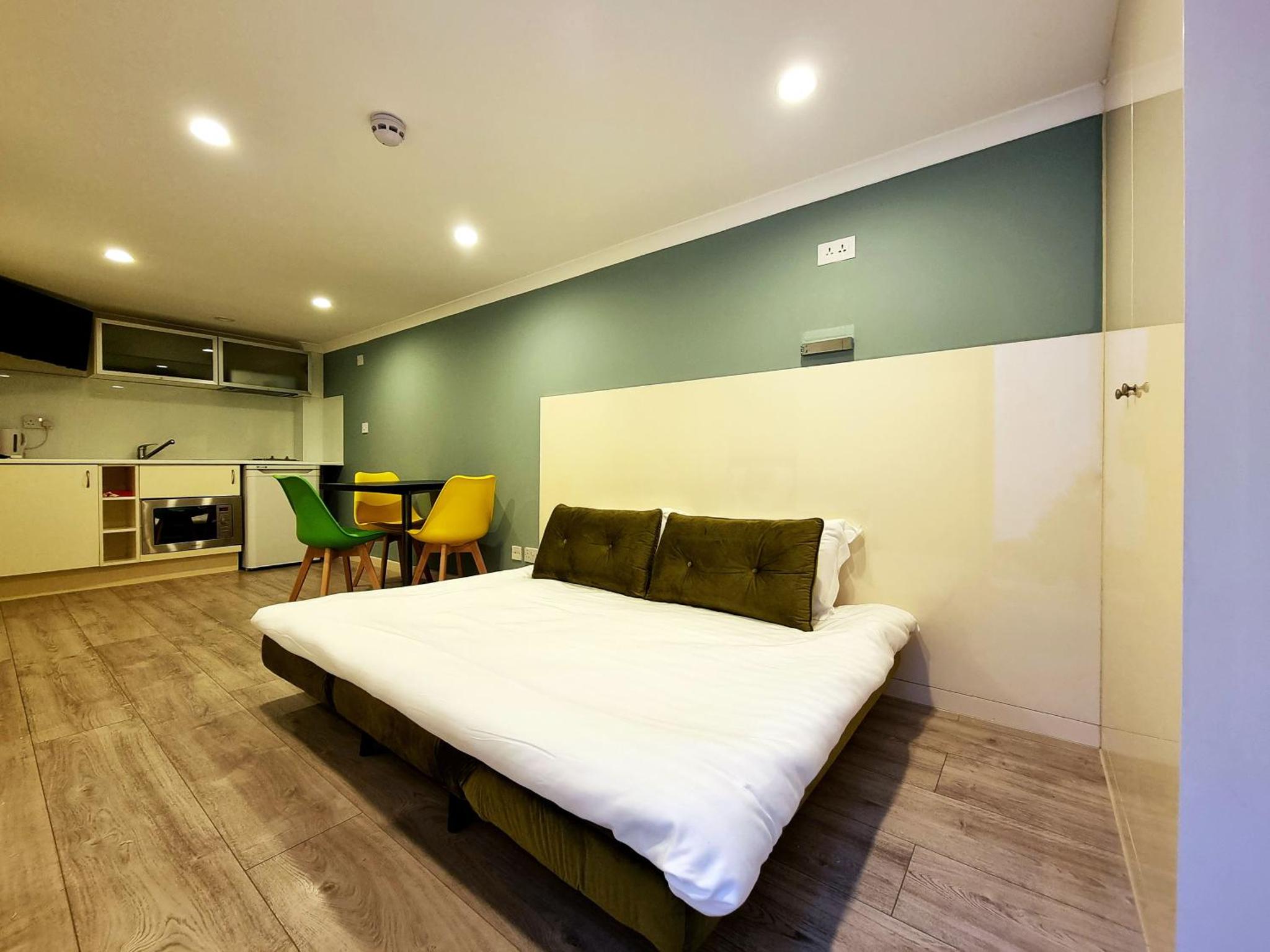 a bedroom with a large bed with a green wall at 146 Studios in London +22 photos