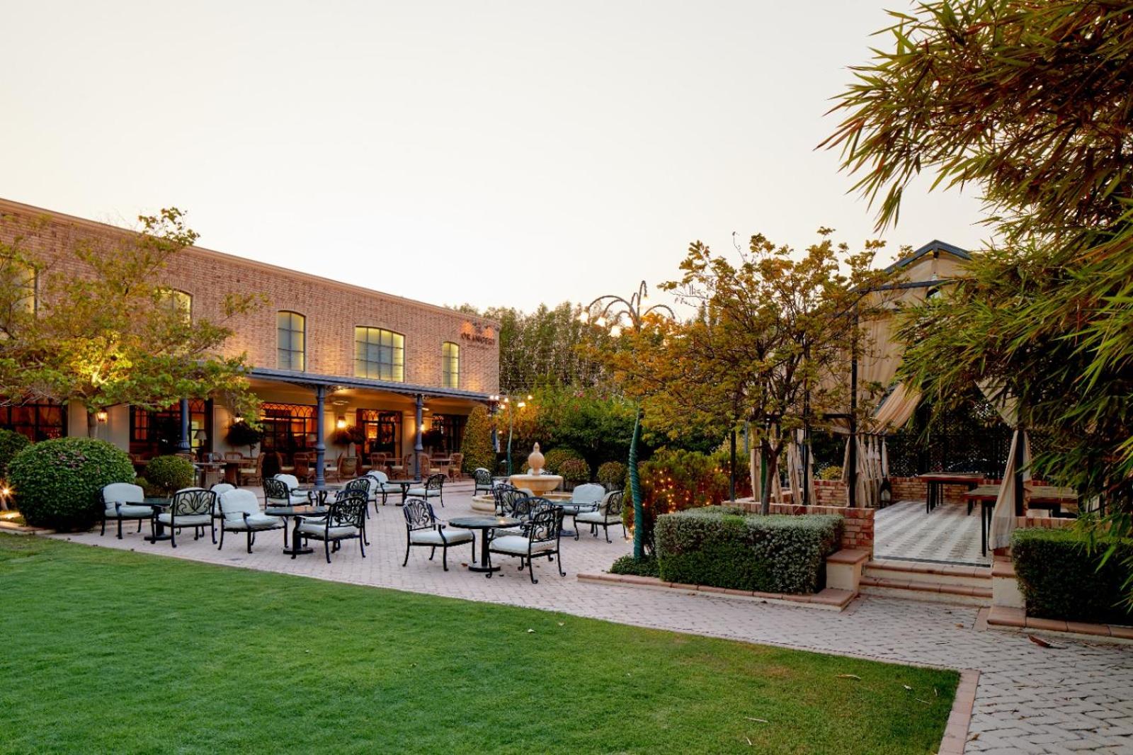 a patio with tables and chairs in a courtyard at Palmyard Hotel in Manama