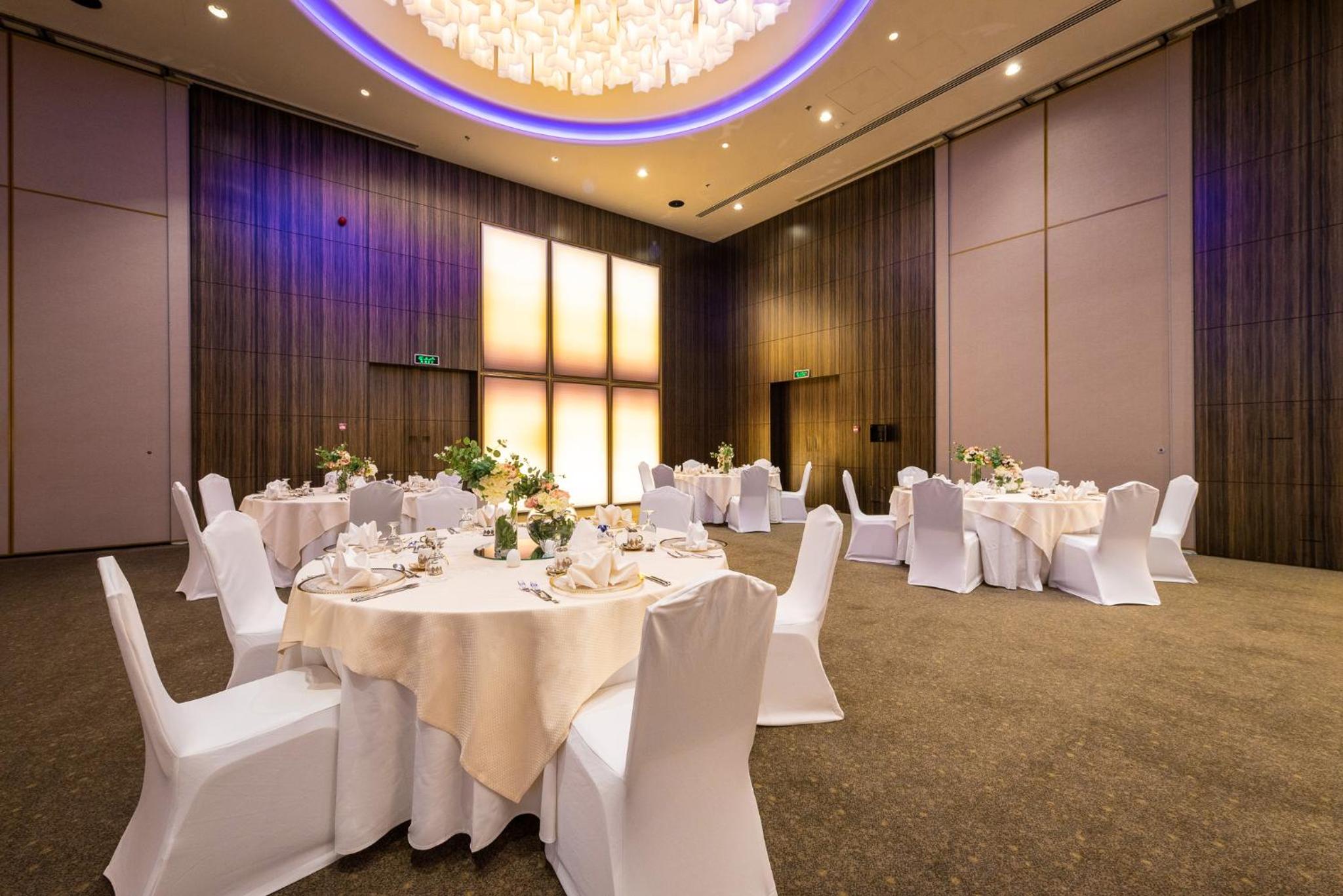 a banquet hall with white tables and chairs and a chandelier at The Art Hotel & Resort in Manama +277 photos
