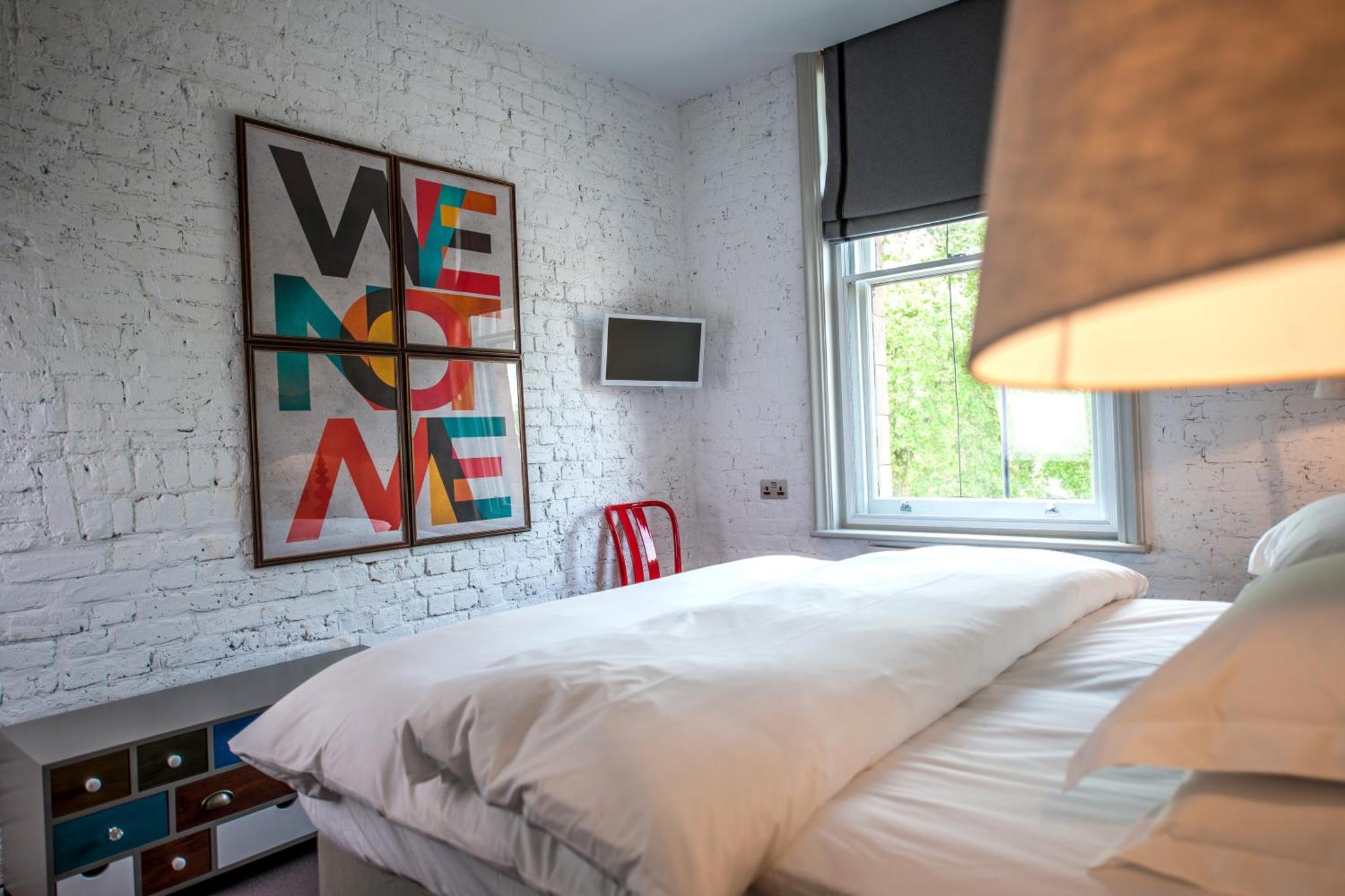 a bedroom with a large white bed and a window at The Tommyfield Hotel in London +16 photos