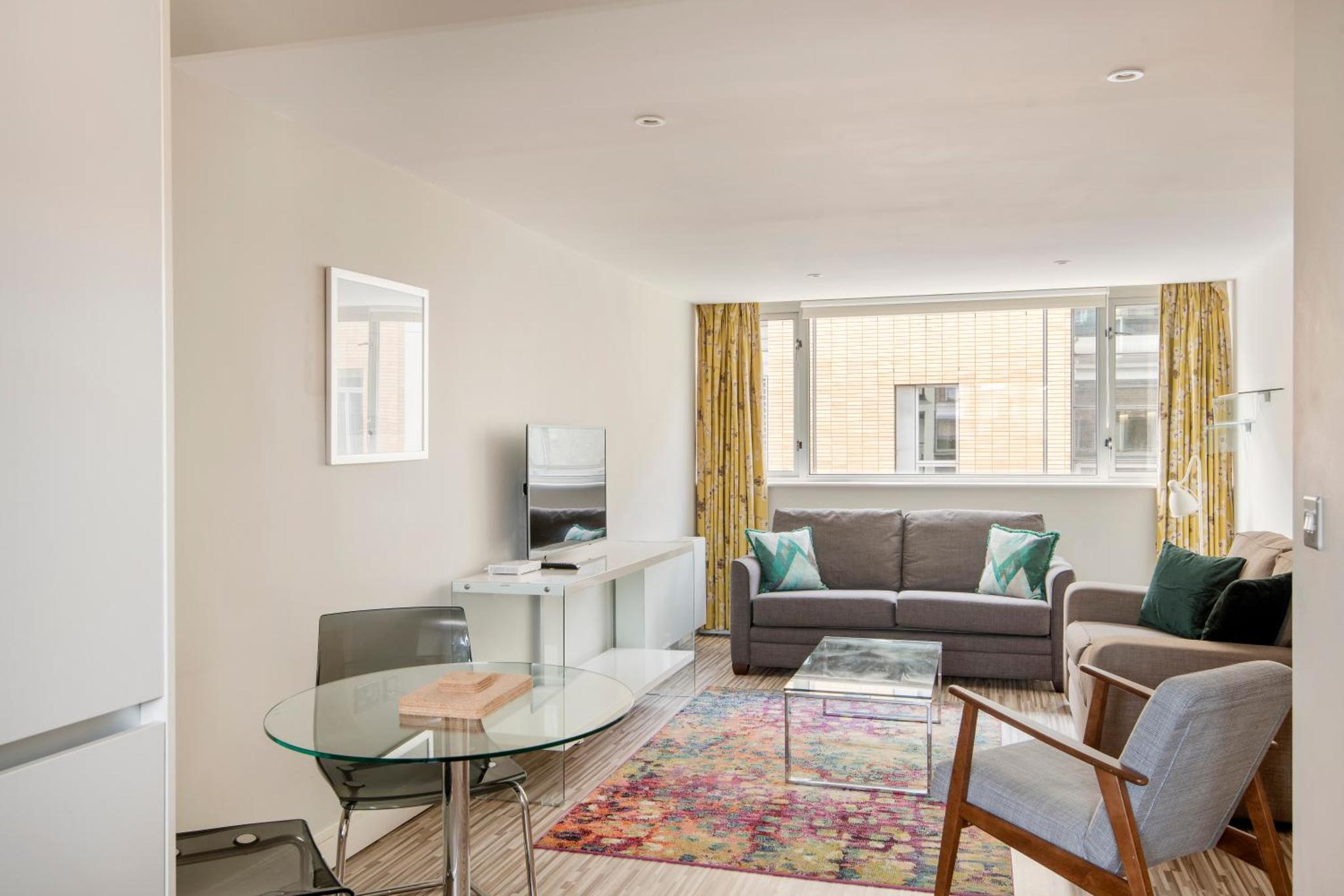 a living room with a couch and a glass table at SACO Holborn – Lamb’s Conduit St in London