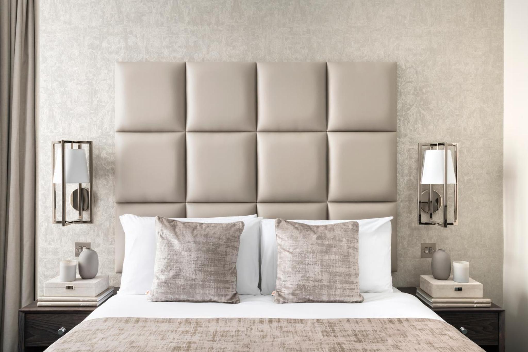 a bedroom with a large white bed with two lamps at The Crescent Hyde Park in London