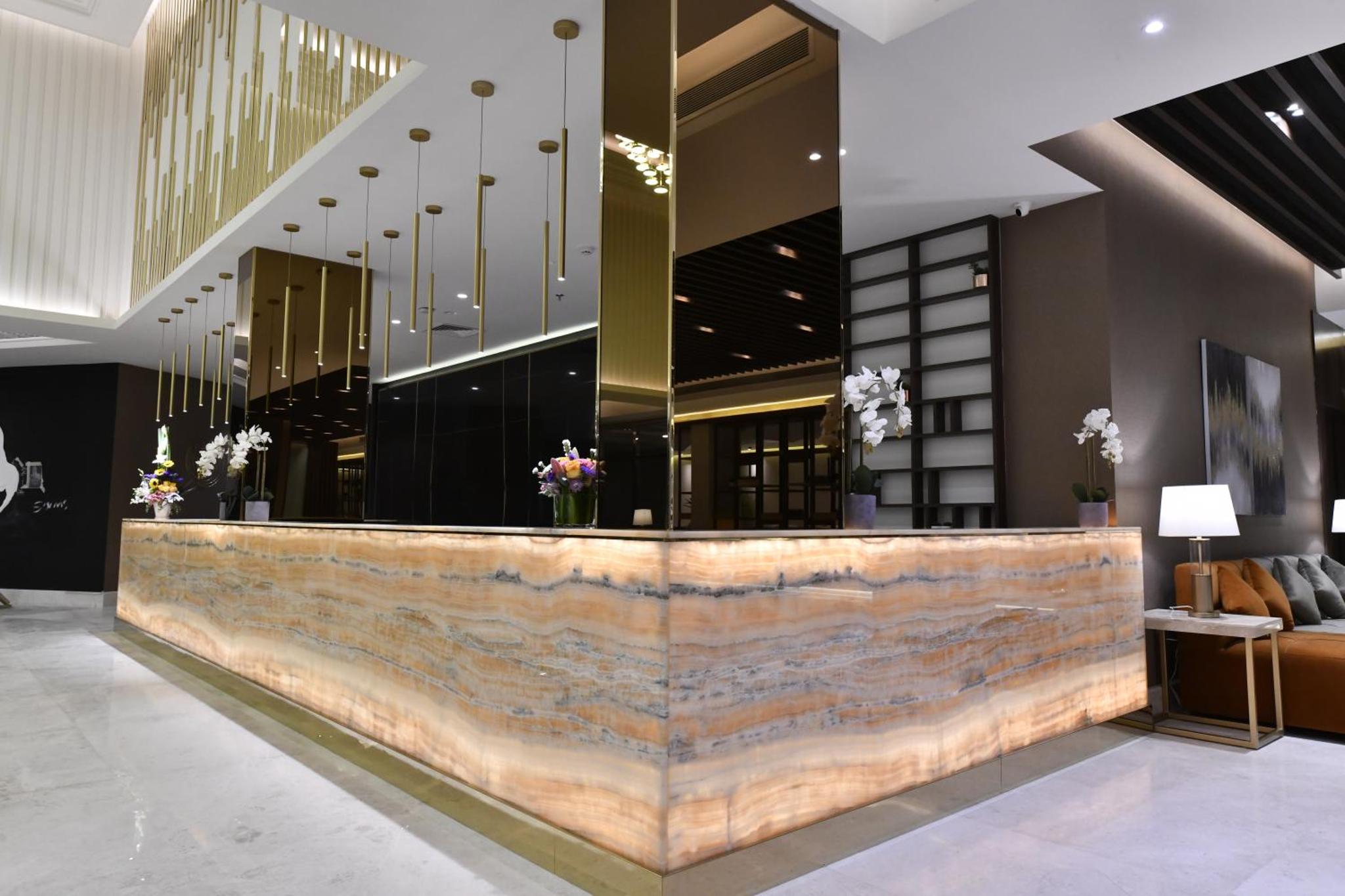 a lobby with a large stone counter in a building at JUFFAIR BOULEVARD HOTEL & SUITES in Juffair +70 photos