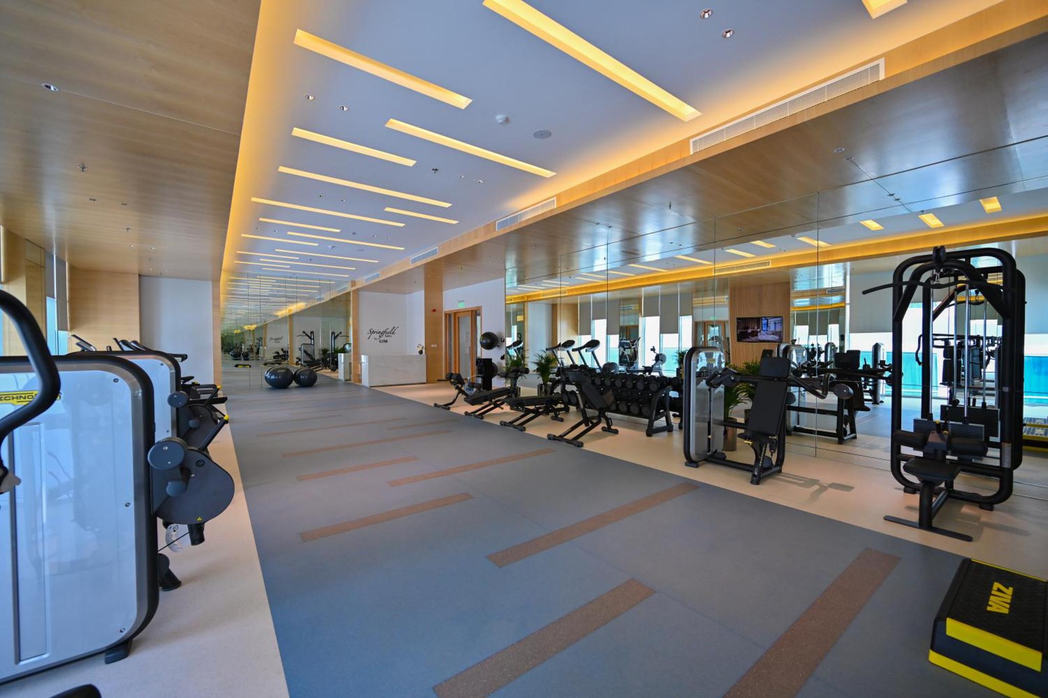 a gym with cardio equipment in a building at Springfield Suites in Seef