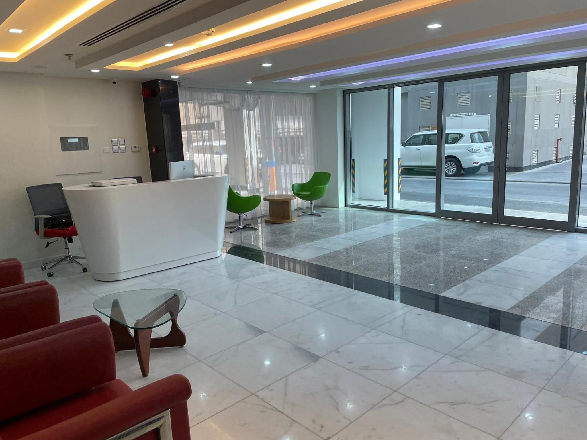 an office with a waiting area with chairs and a table at The Apple Residence in Juffair +39 photos