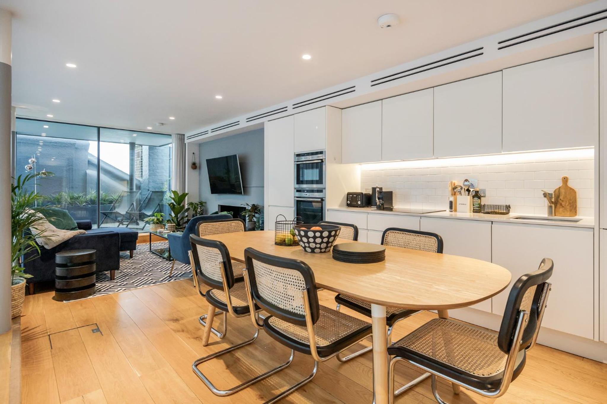a kitchen and dining room with a table and chairs at Stay Kula London - Holborn in London