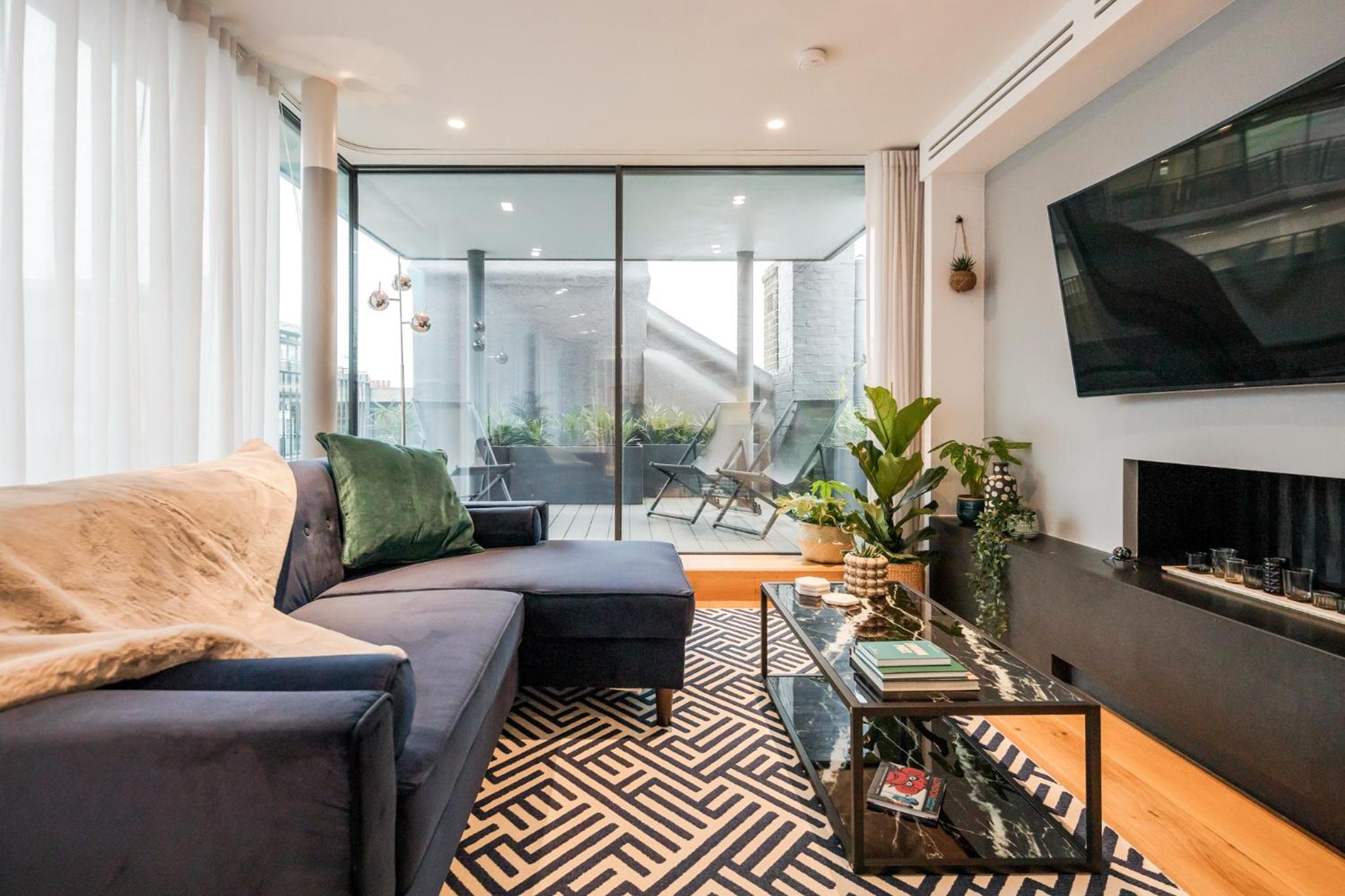 a living room with a couch and a fireplace at Stay Kula London - Holborn in London