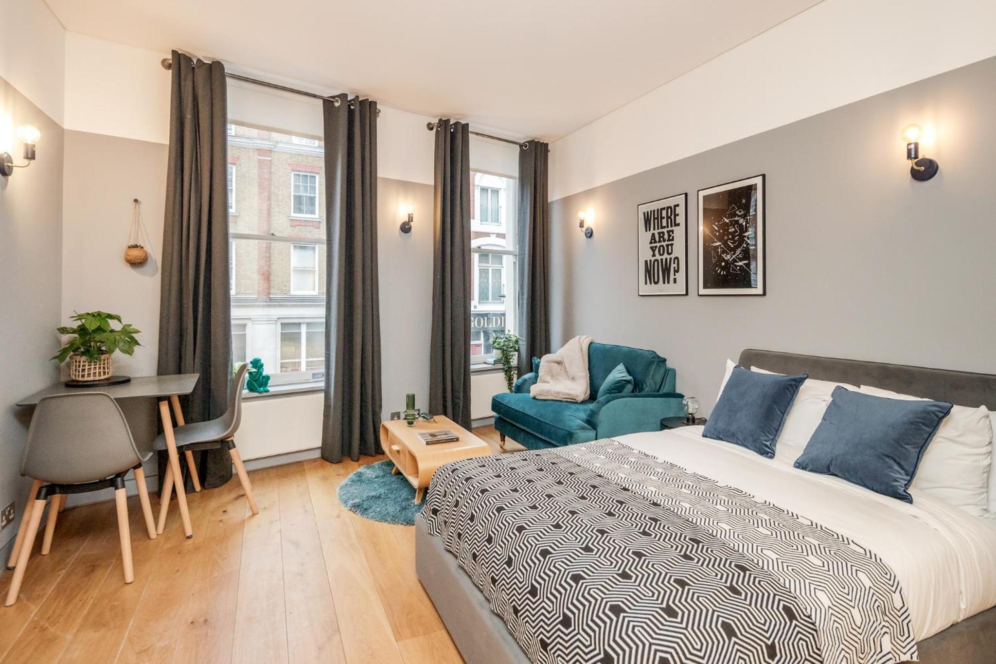 a bedroom with a bed and a desk and a chair at Stay Kula London - Holborn in London