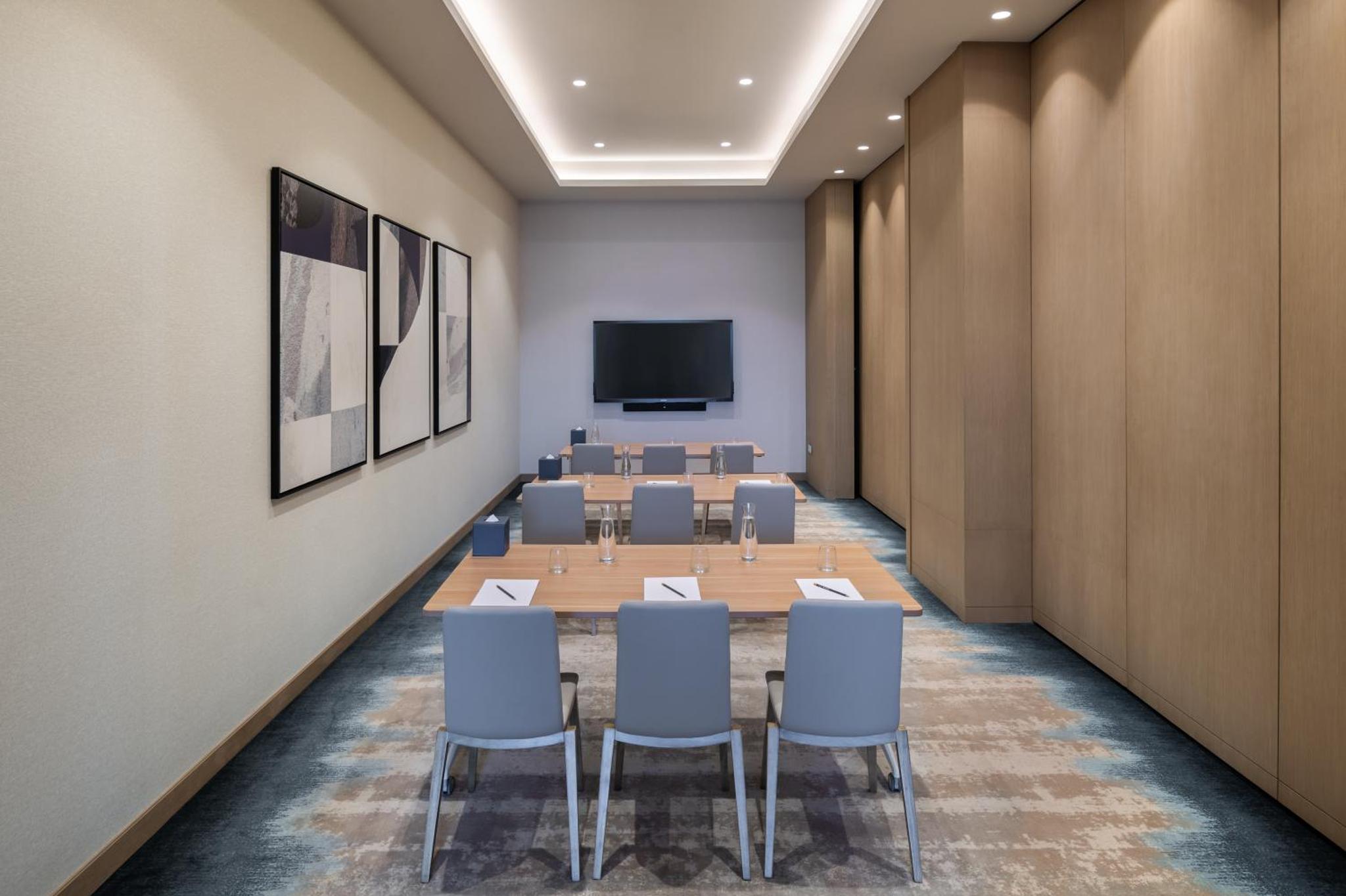 a conference room with tables and chairs and a tv at Vida Beach Resort Marassi Al Bahrain in Manama +71 photos