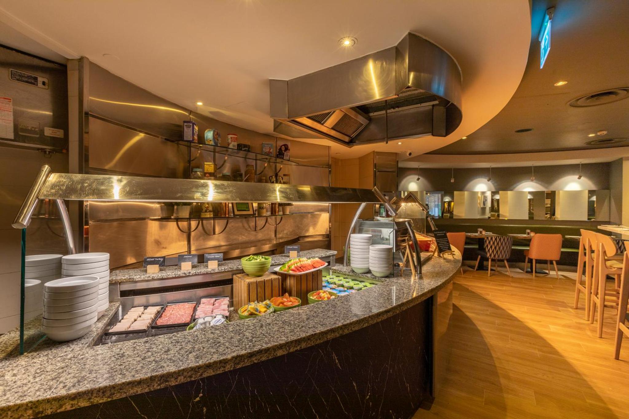 a restaurant kitchen with a counter with food at Holiday Inn London - Regent's Park by IHG in London