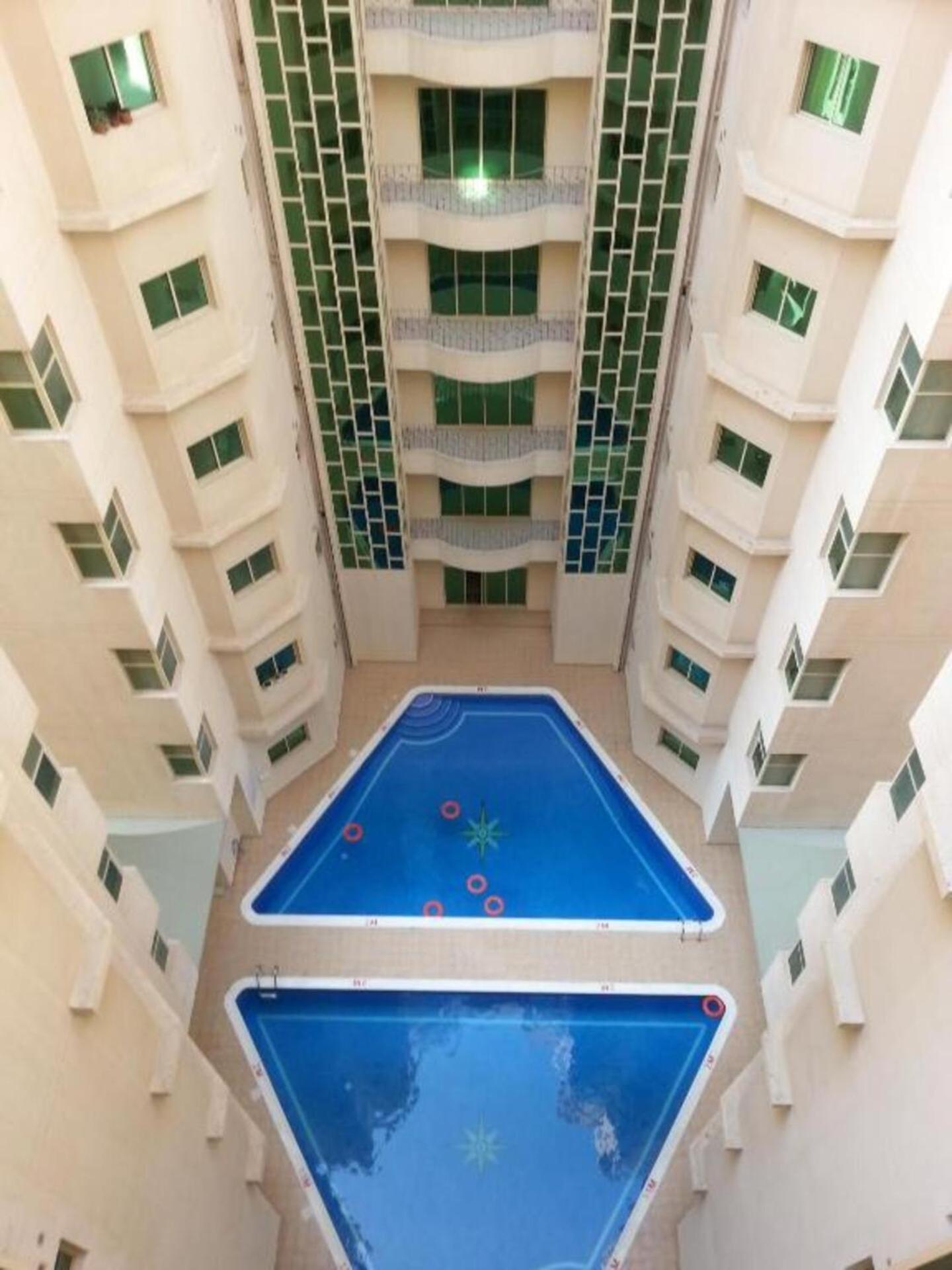 a pool in the middle of a building at Oryx Tower in Manama