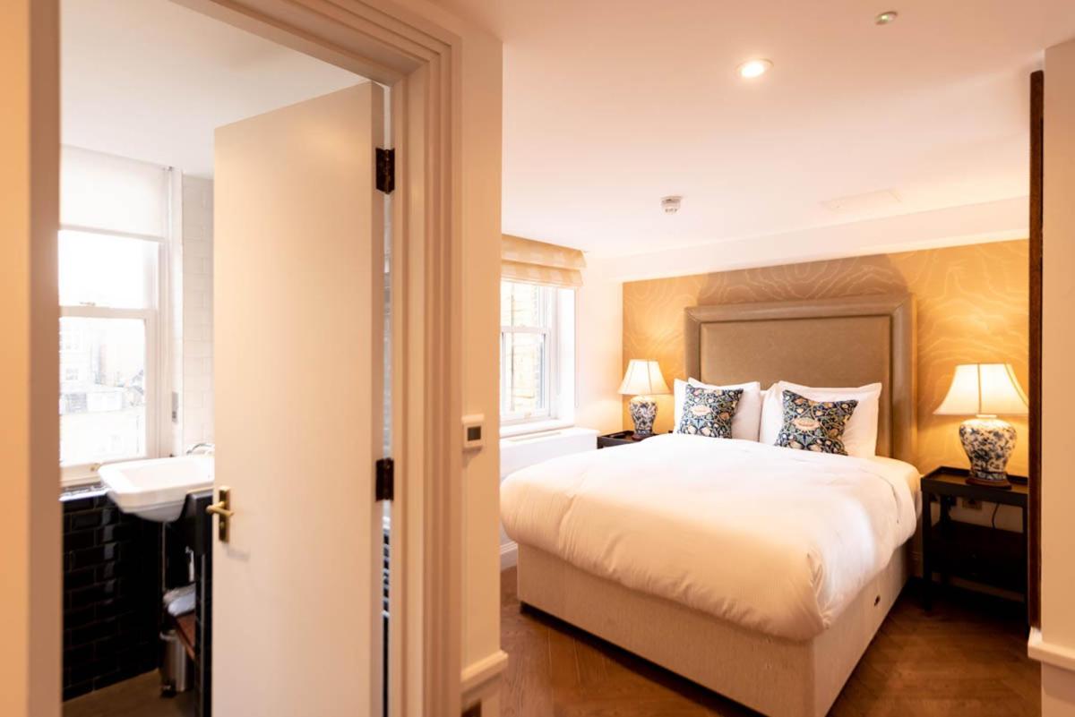 a bedroom with a large white bed and a window at Gunmakers in London