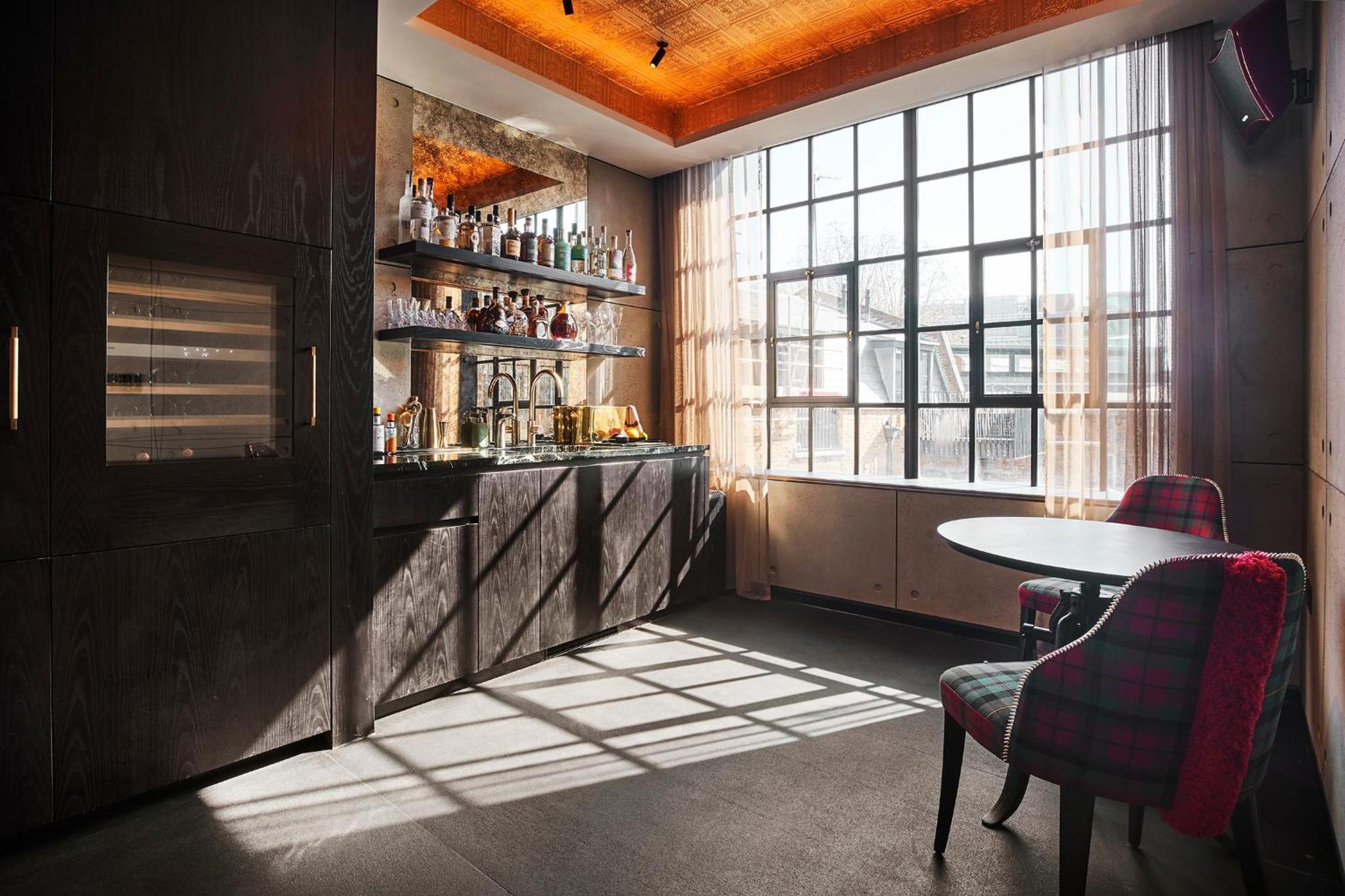 a bar with a table and chairs and a window at Chateau Denmark London in London