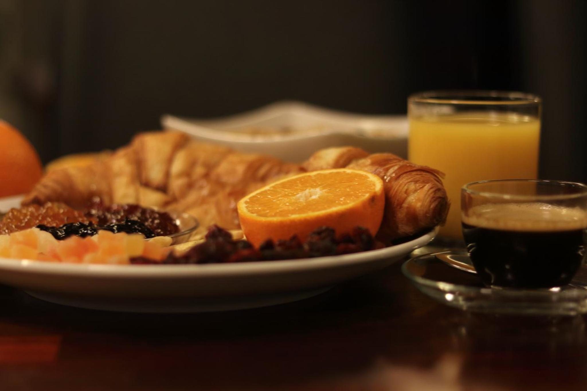 a plate of food on a table with an orange slice at The Bryson Hotel in London