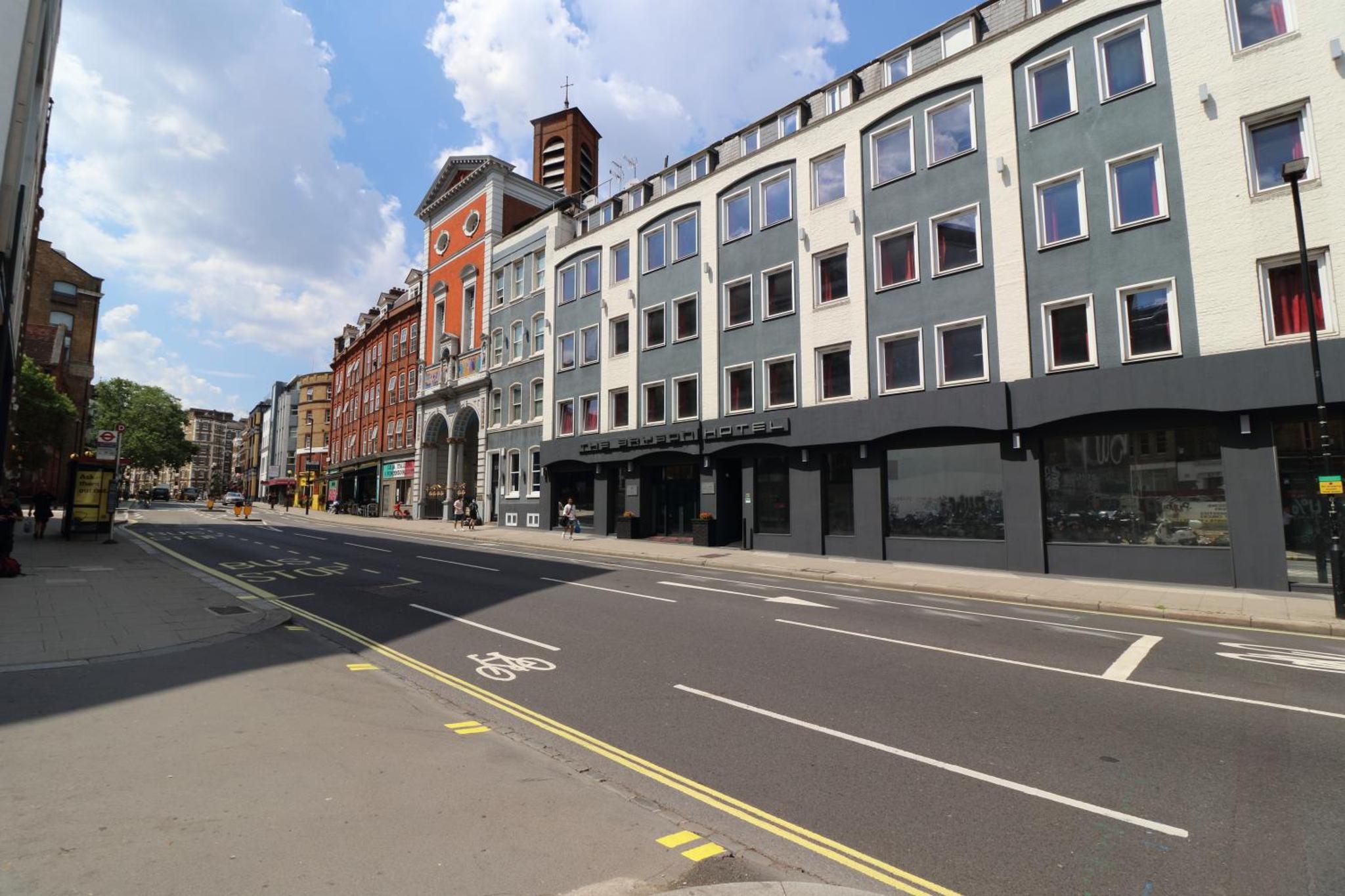 an empty street in a city with buildings at The Bryson Hotel in London
