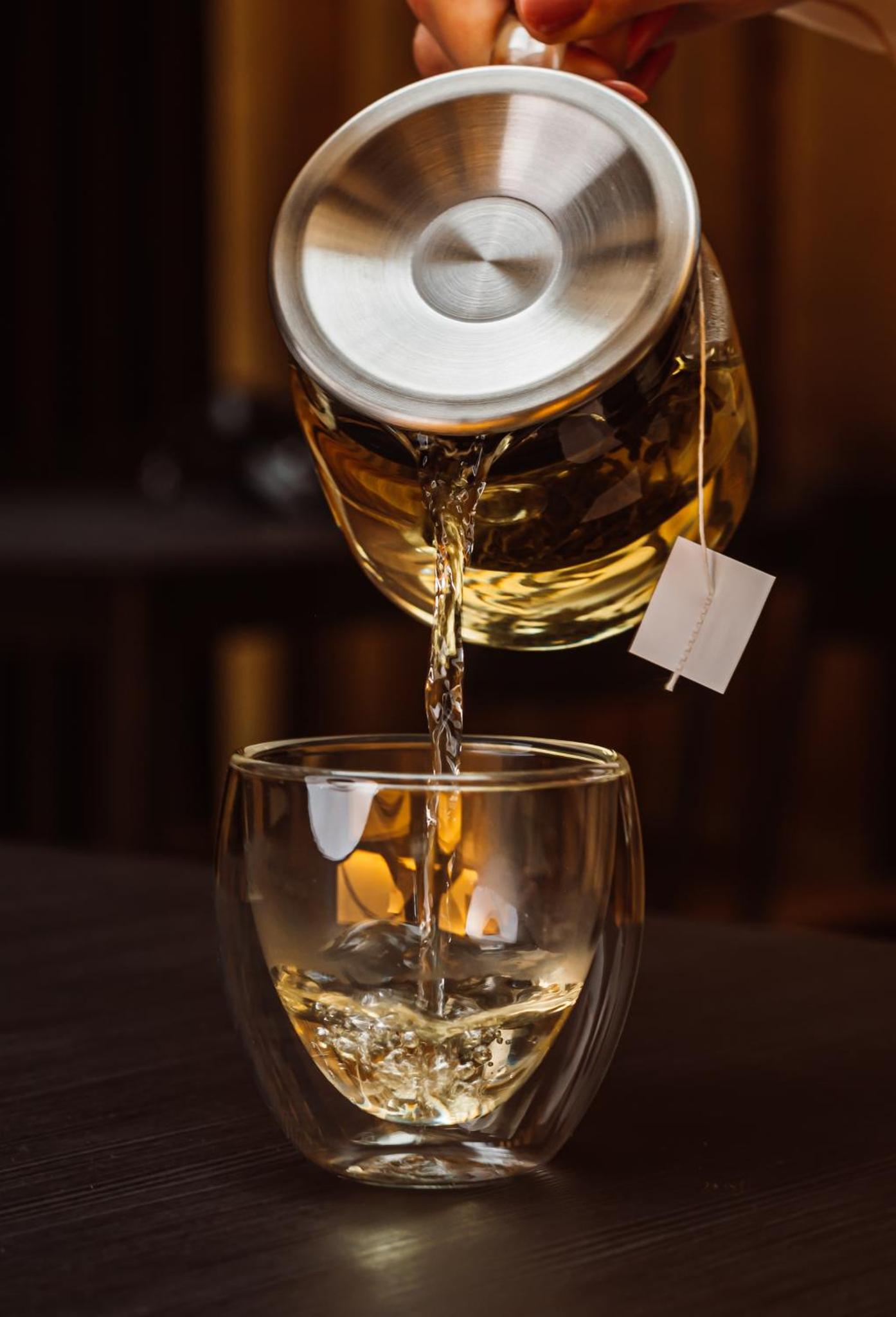 a person pouring whiskey into a glass bowl at Dorsett Shepherds Bush London in London