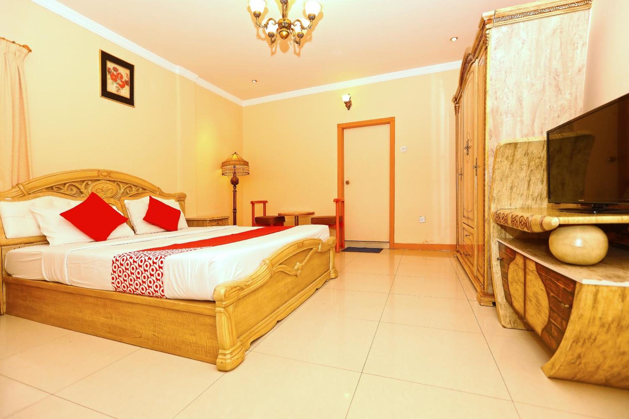 a bedroom with a bed and a flat screen tv at Sea Shell Hotel in Manama