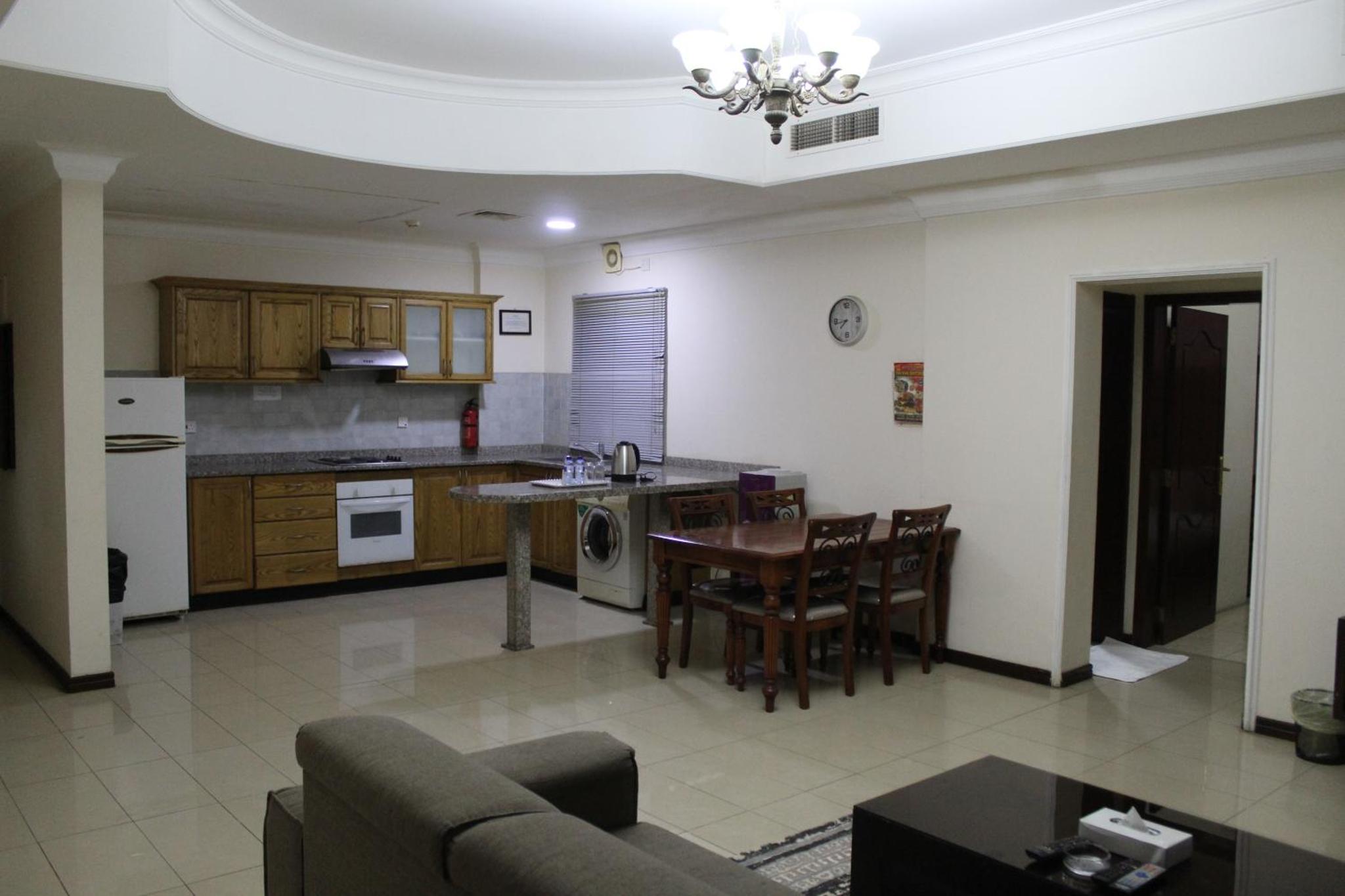 a kitchen and living room with a couch and a table at Caesar Palace in Al Ghurayfah