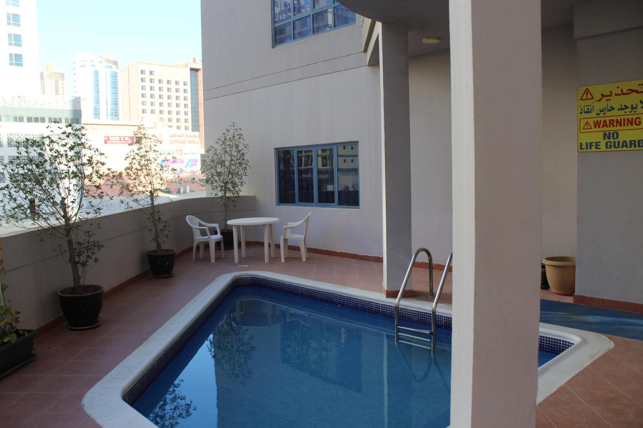 a swimming pool on the side of a building at Caesar Palace in Al Ghurayfah