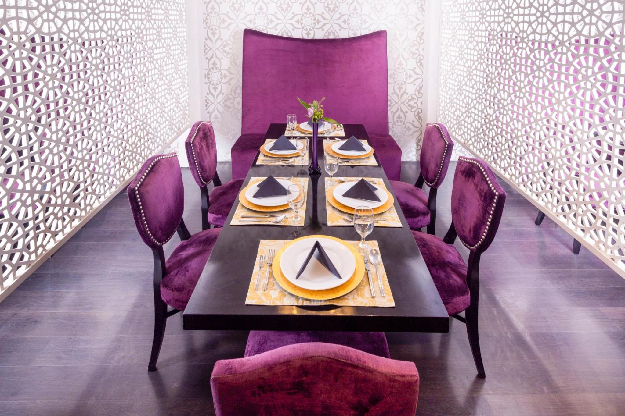 a dining room with a table and purple chairs at Nordic Palace and spa in Manama +31 photos