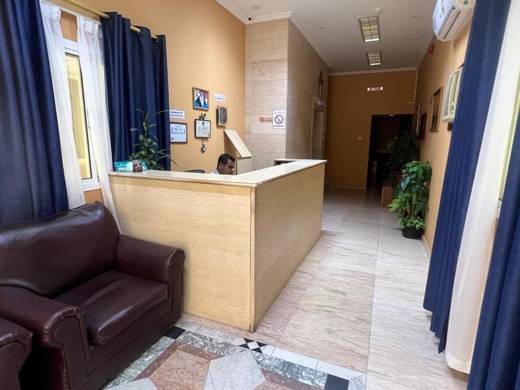 a man sitting at a reception desk in a hospital lobby at Canary Islands in Manama
