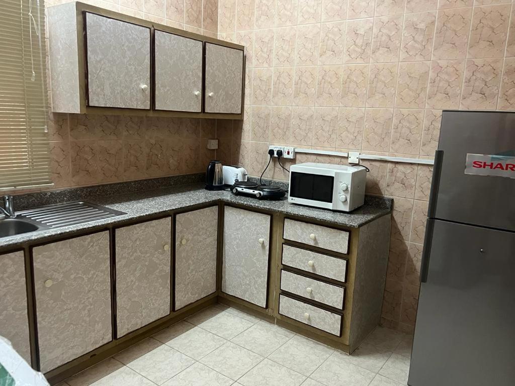 a kitchen with a microwave and a refrigerator at Canary Islands in Manama
