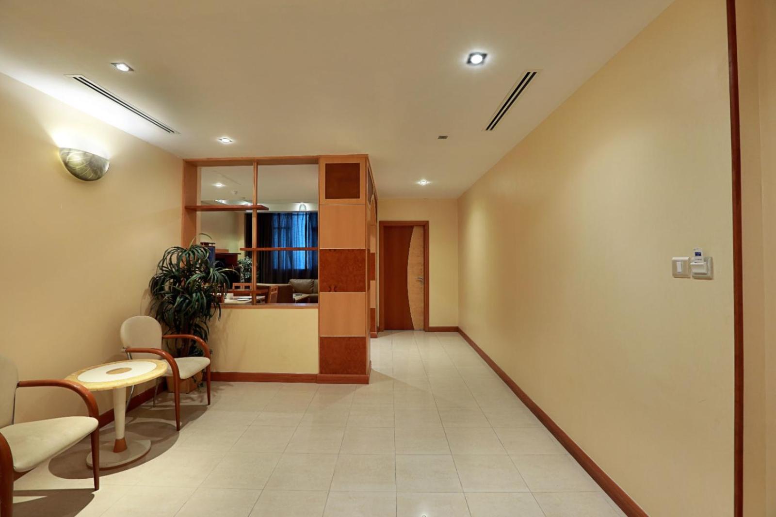 a hallway with a waiting room with chairs and a table at Elite Tower in Seef +36 photos