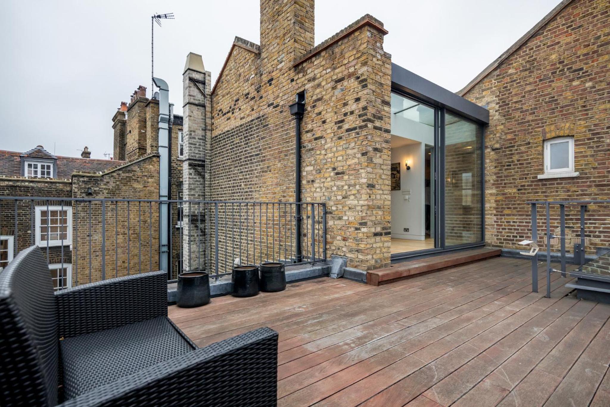 a balcony with a brick building with glass doors at Stay Kula London - Holborn in London