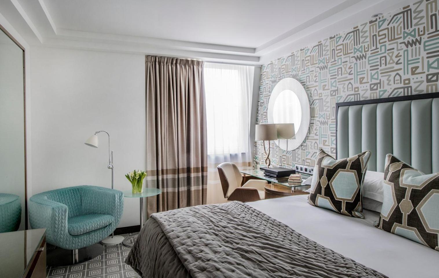 a bedroom with a bed and a chair and a desk at The Marylebone Hotel in London